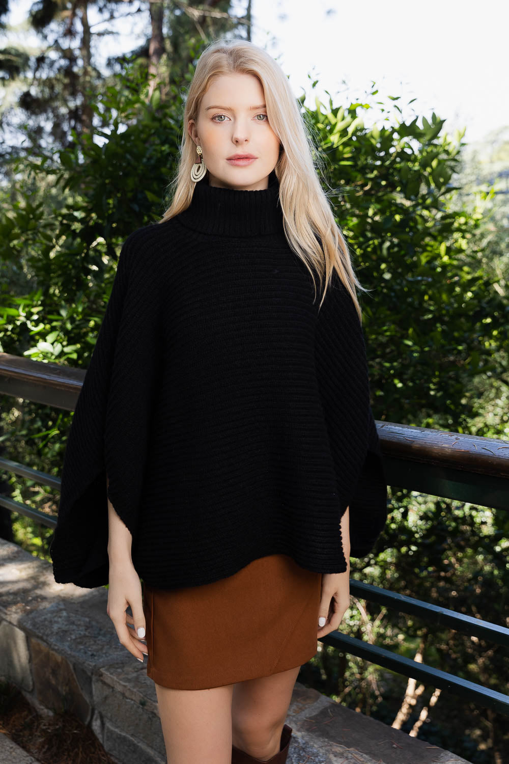 SnugStyle Turtleneck Ribbed Knit Poncho with Armholes in a cozy setting, showcasing its stylish ribbed texture and turtleneck design.