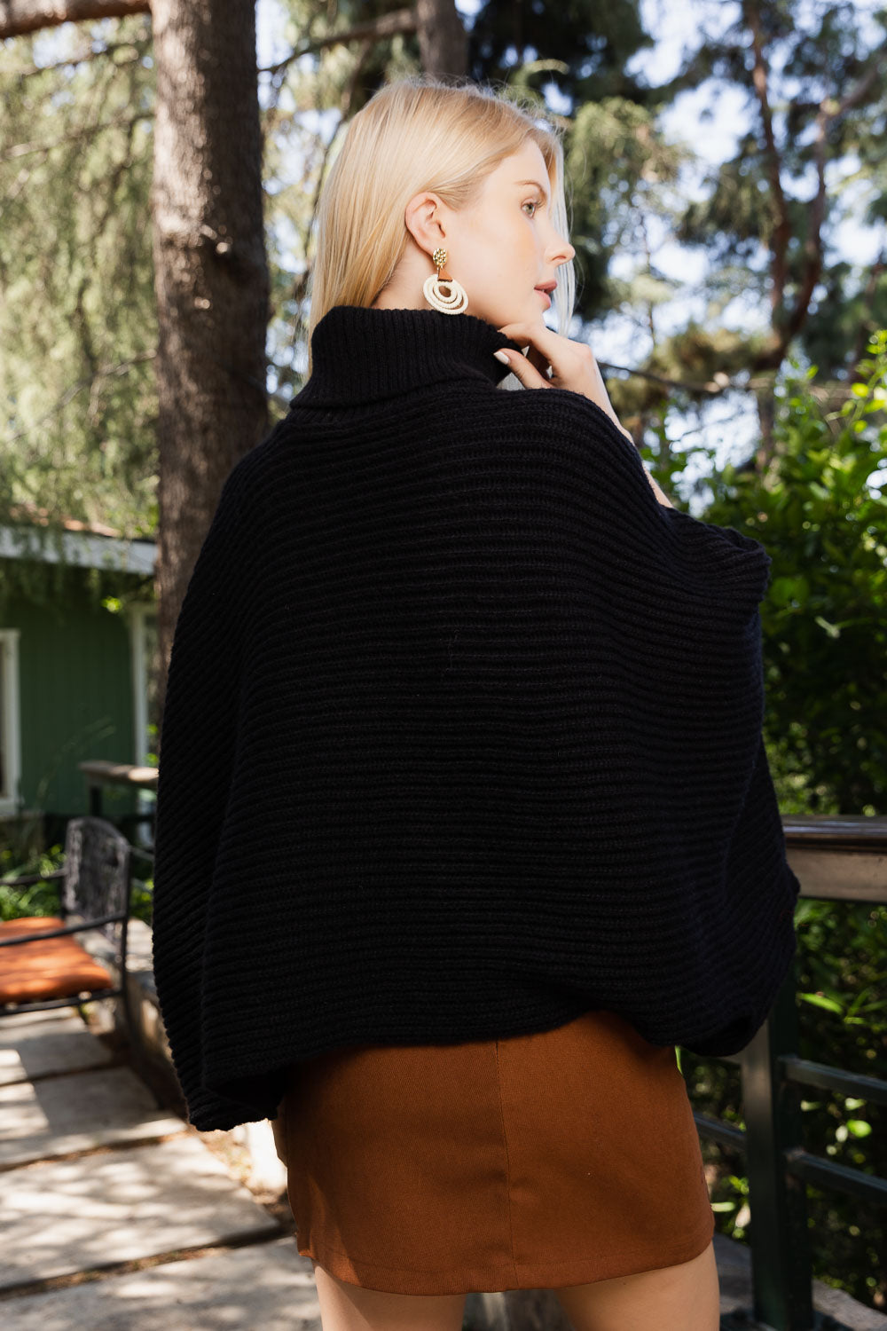 SnugStyle Turtleneck Ribbed Knit Poncho with Armholes in a cozy setting, showcasing its stylish ribbed texture and turtleneck design.