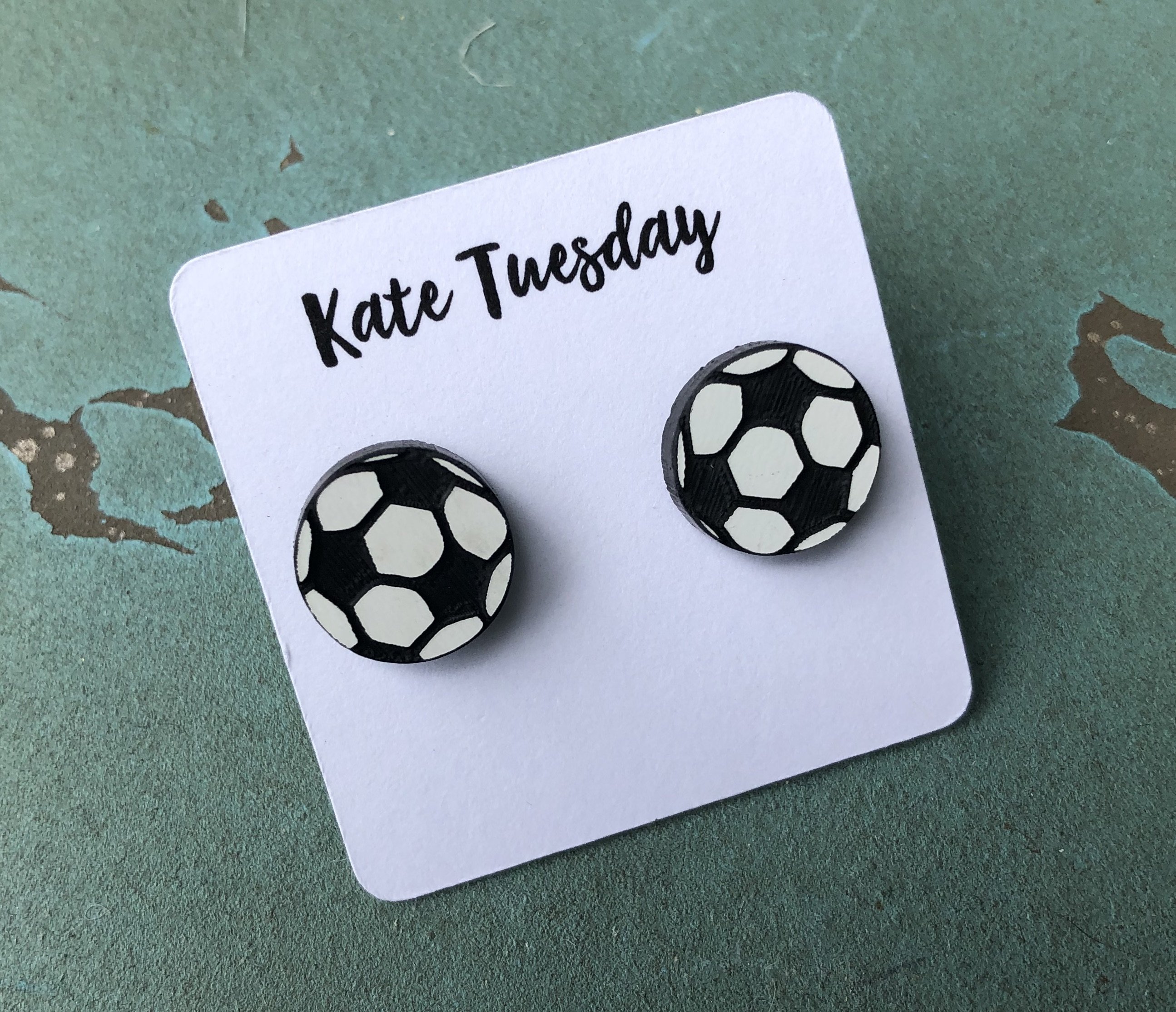 A pair of 12mm soccer stud earrings featuring a classic black and white soccer ball design with black back sides.