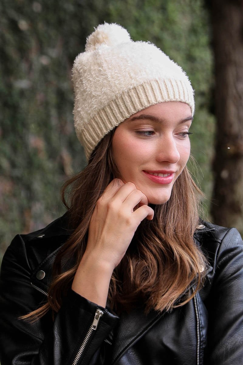 A stylish soft furry pom knit beanie in a cozy blend of nylon and acrylic, featuring a playful pom on top, perfect for winter wear.