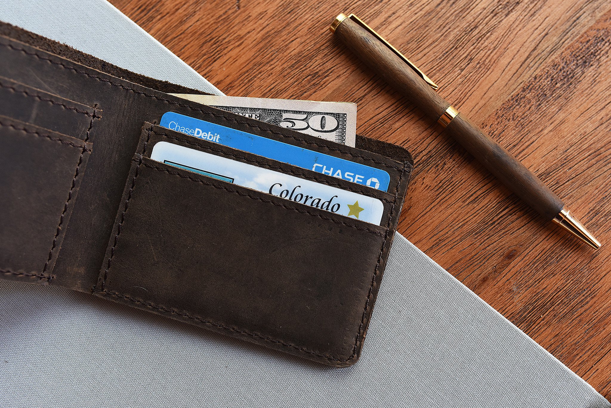 Step Up Wallet showcasing four card slots and a bill compartment in rich leather with dark stitching.