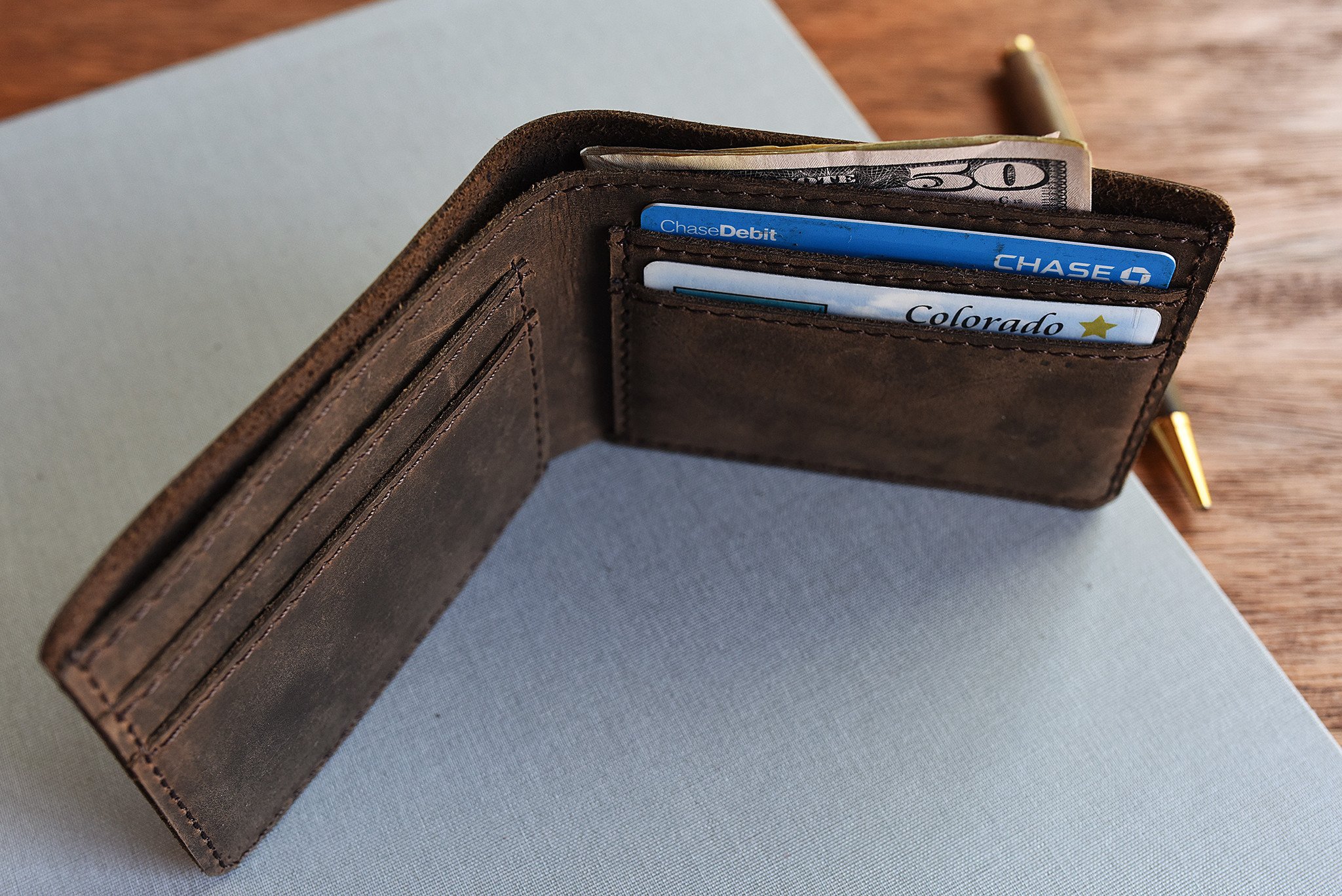 Step Up Wallet showcasing four card slots and a bill compartment in rich leather with dark stitching.