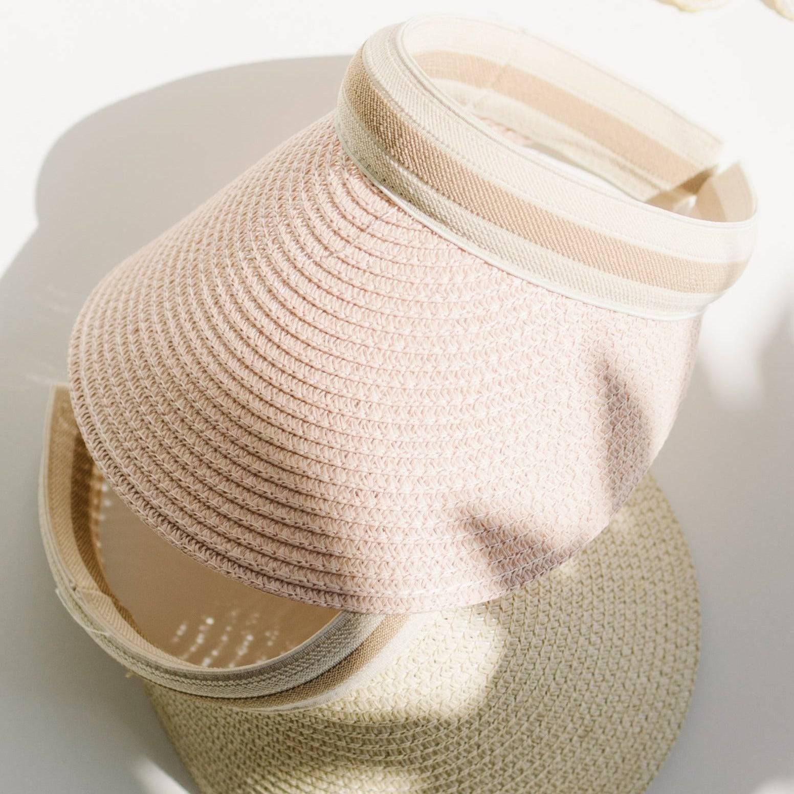 Stylish straw visor with adjustable band, perfect for summer sun protection.