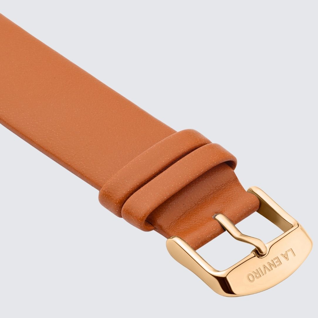 Tan unstitched watch strap made from vegan leather, featuring a quick release pin and stainless steel buckle in rose gold.