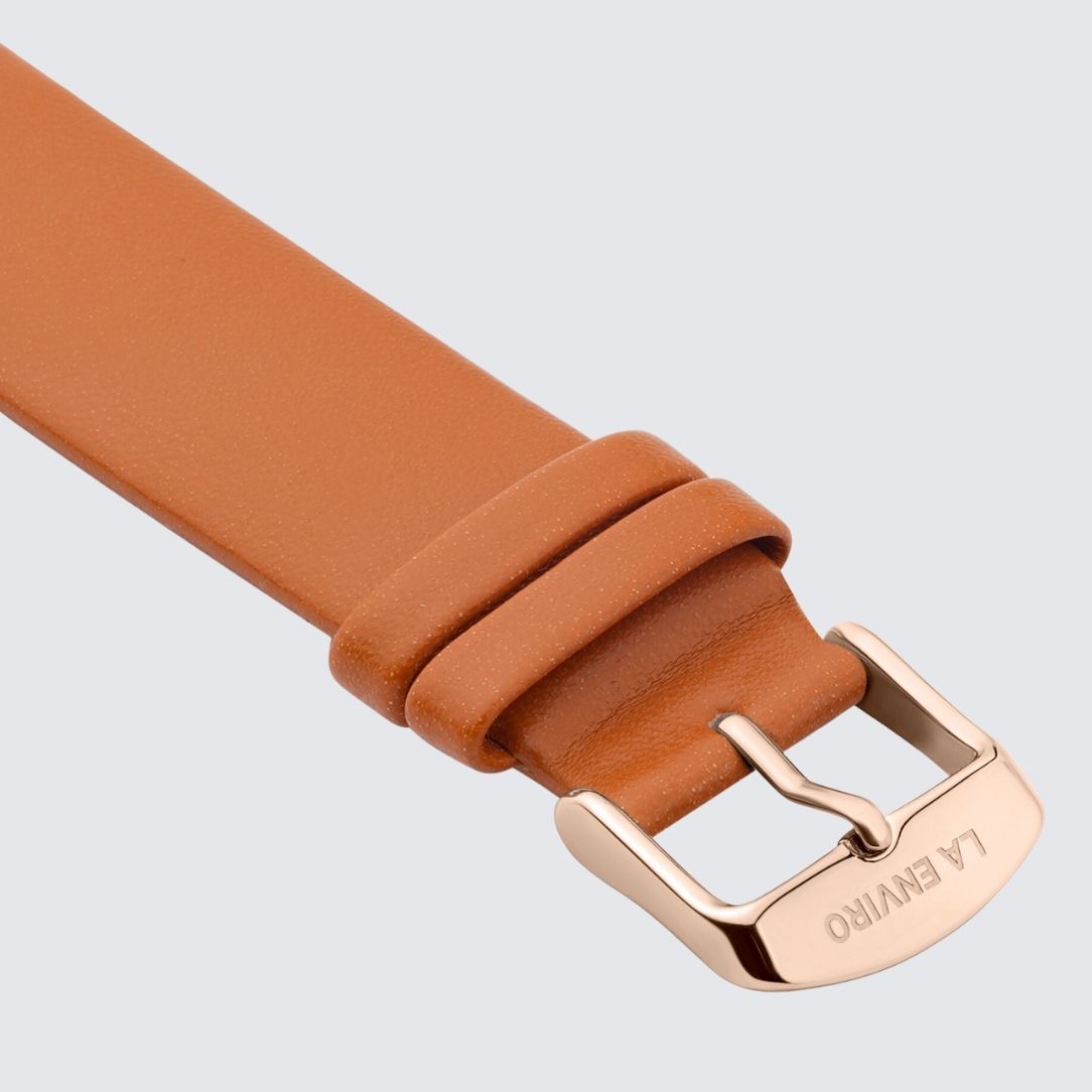 Tan unstitched watch strap made from vegan leather, featuring a quick release pin and stainless steel buckle in rose gold.