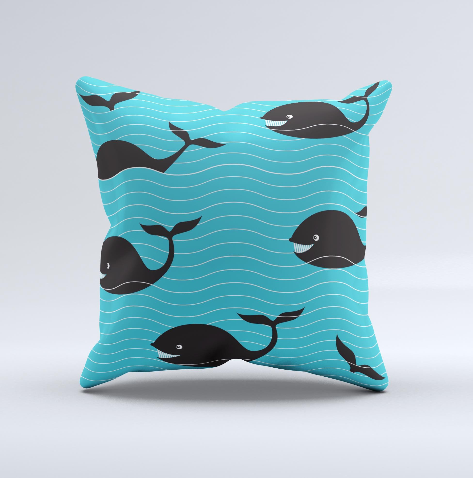 Teal decorative throw pillow featuring a smiling black whale pattern, showcasing vibrant colors and a unique handmade design.