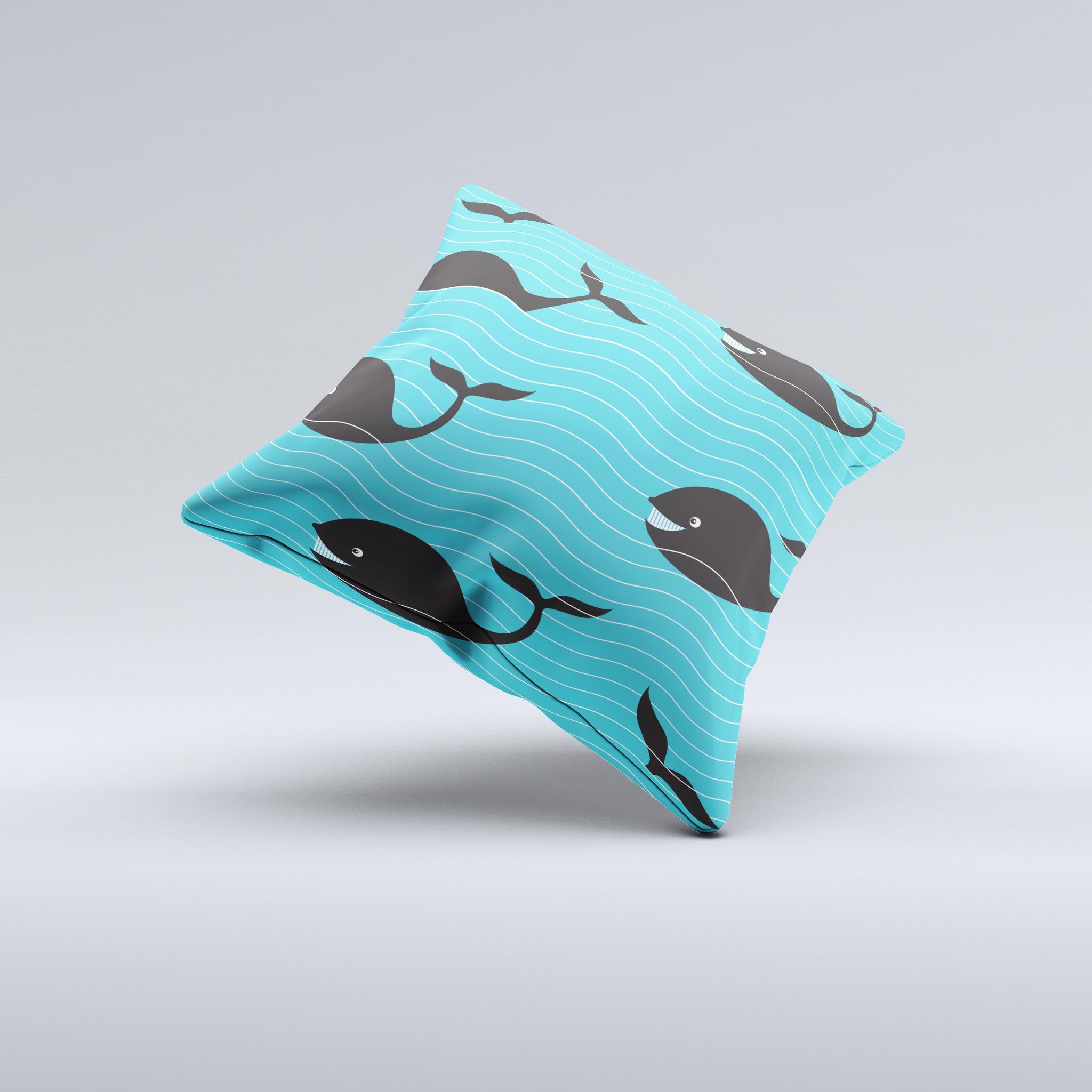 Teal decorative throw pillow featuring a smiling black whale pattern, showcasing vibrant colors and a unique handmade design.