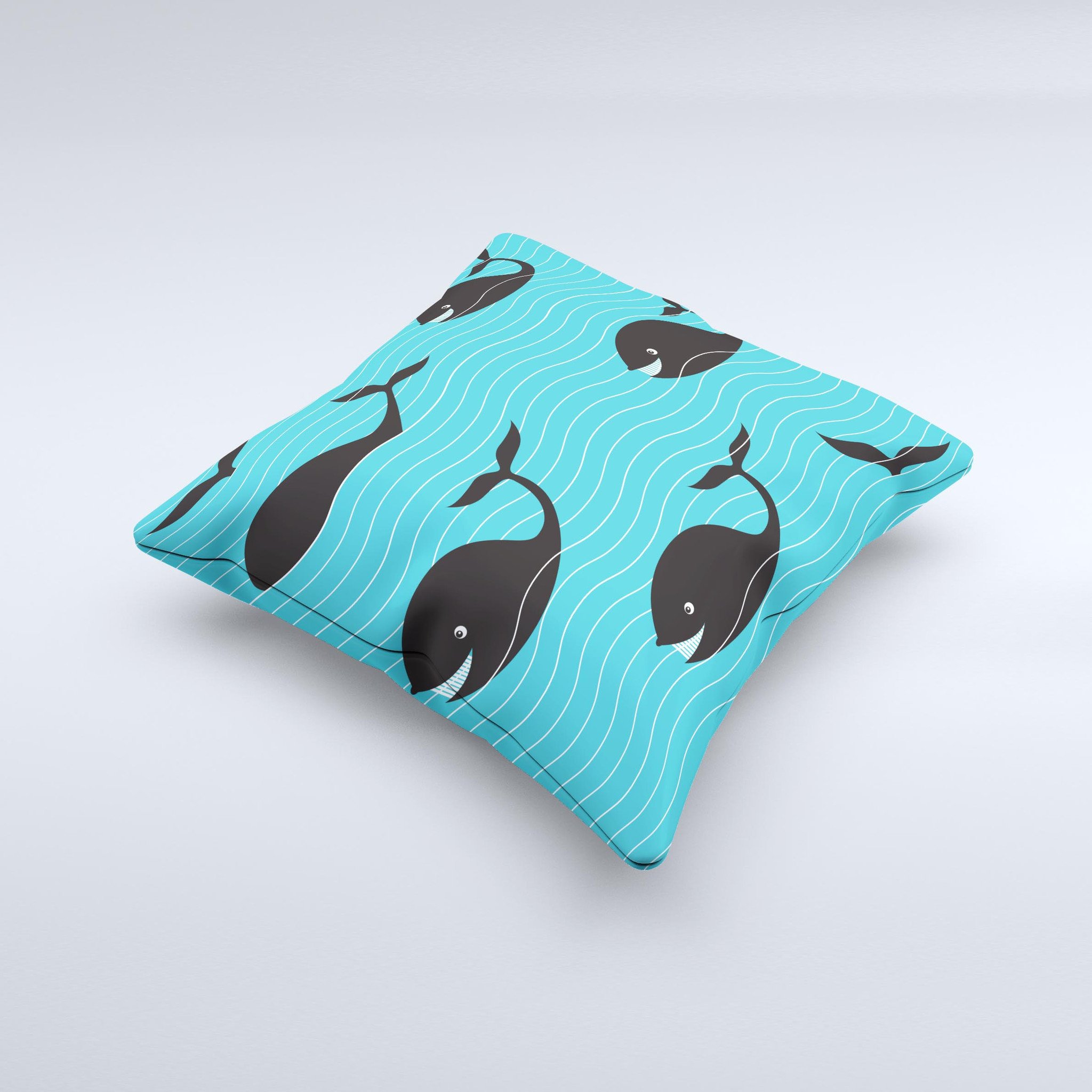 Teal decorative throw pillow featuring a smiling black whale pattern, showcasing vibrant colors and a unique handmade design.