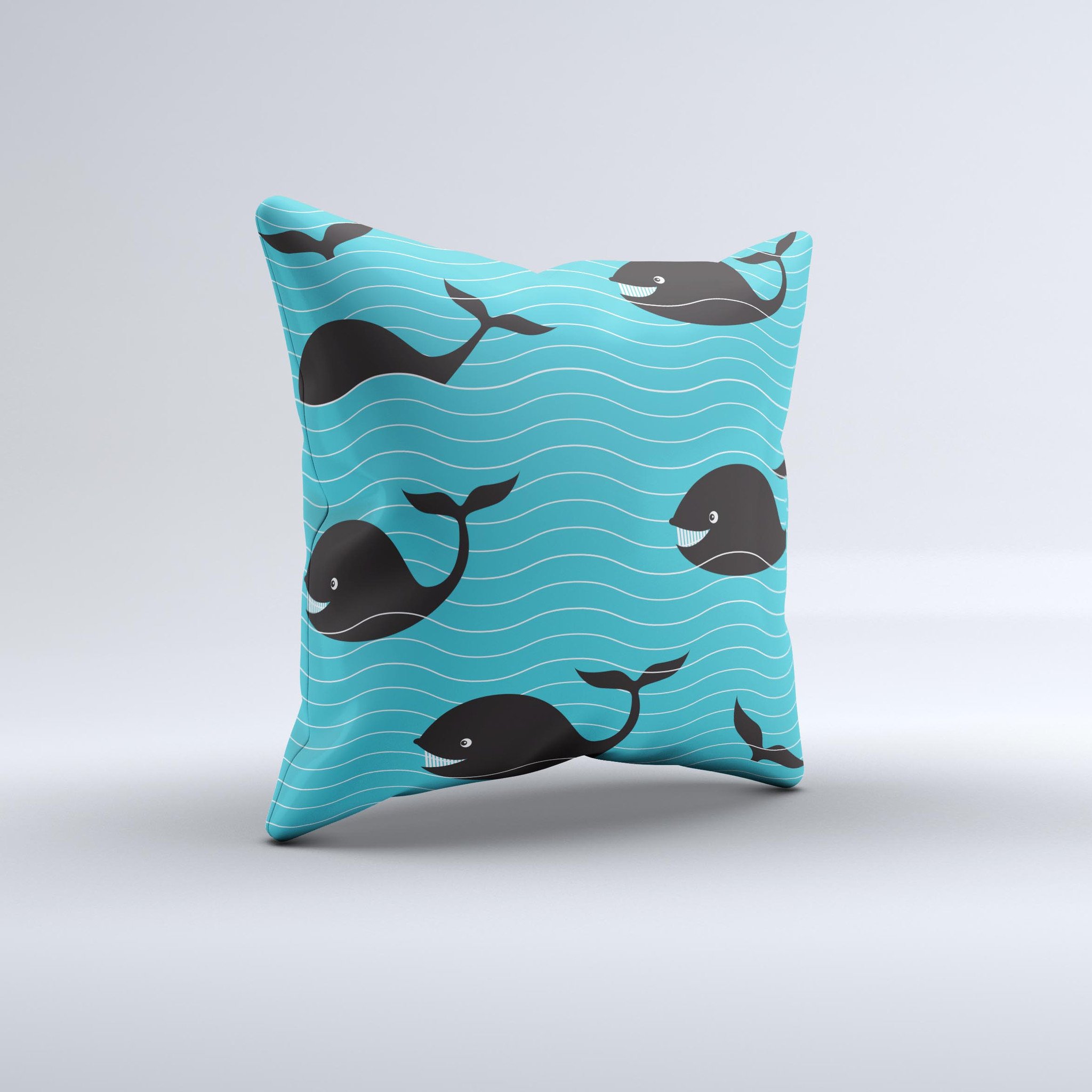 Teal decorative throw pillow featuring a smiling black whale pattern, showcasing vibrant colors and a unique handmade design.