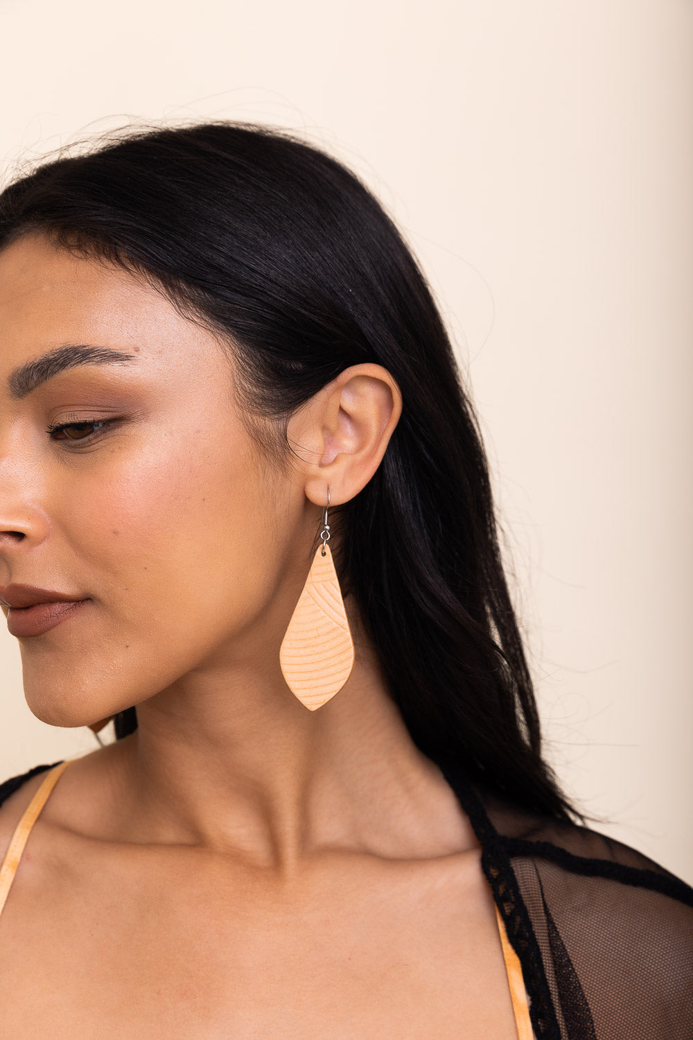 Stylish teardrop leather earrings in a chic design, showcasing their lightweight and elegant appearance.