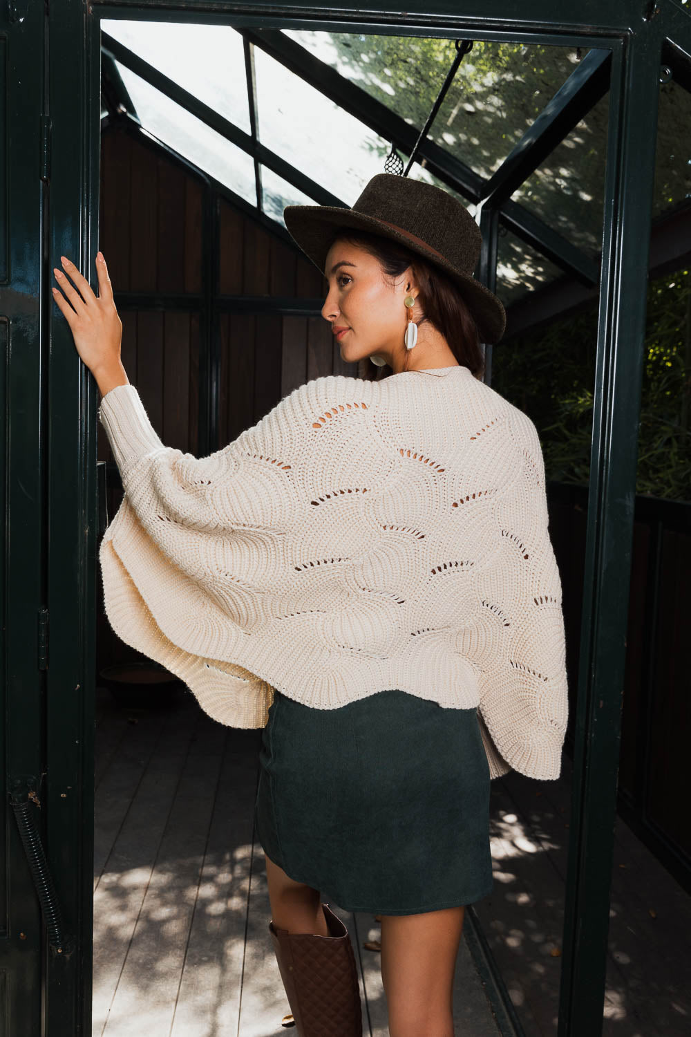 A stylish Texture Trend Sleeve-Knit Poncho featuring a chic ribbed knit design with convenient sleeves, perfect for layering.