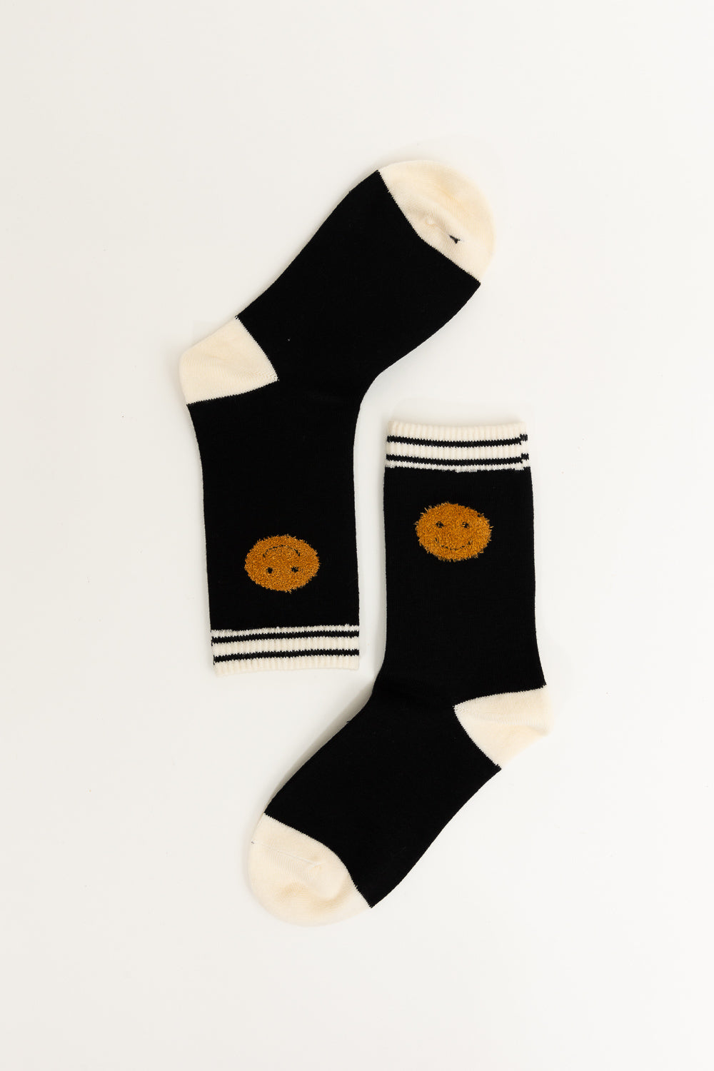 A pair of Threaded Smiles Crew Socks featuring a playful smiley face design, made from soft cashmere for ultimate comfort.