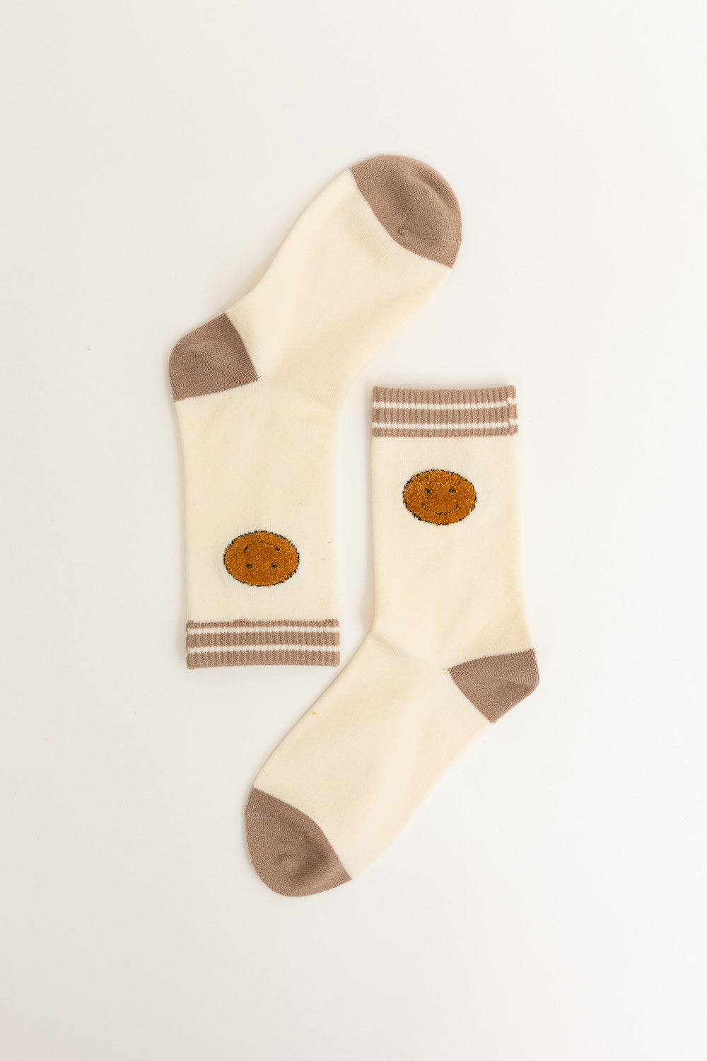 A pair of Threaded Smiles Crew Socks featuring a playful smiley face design, made from soft cashmere for ultimate comfort.