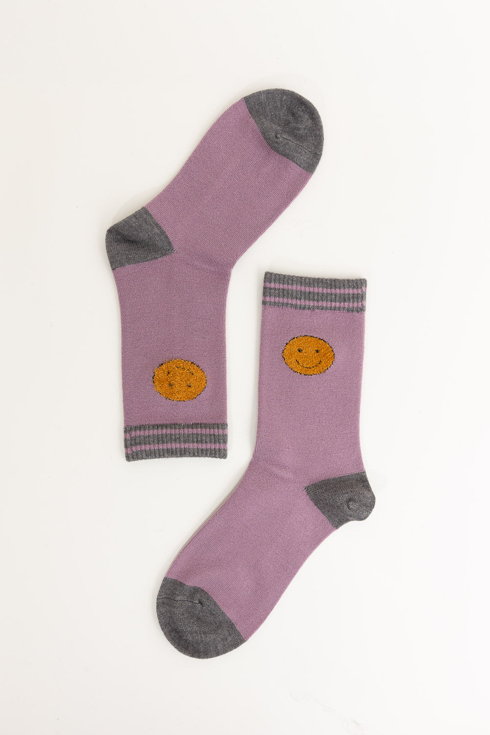 A pair of Threaded Smiles Crew Socks featuring a playful smiley face design, made from soft cashmere for ultimate comfort.