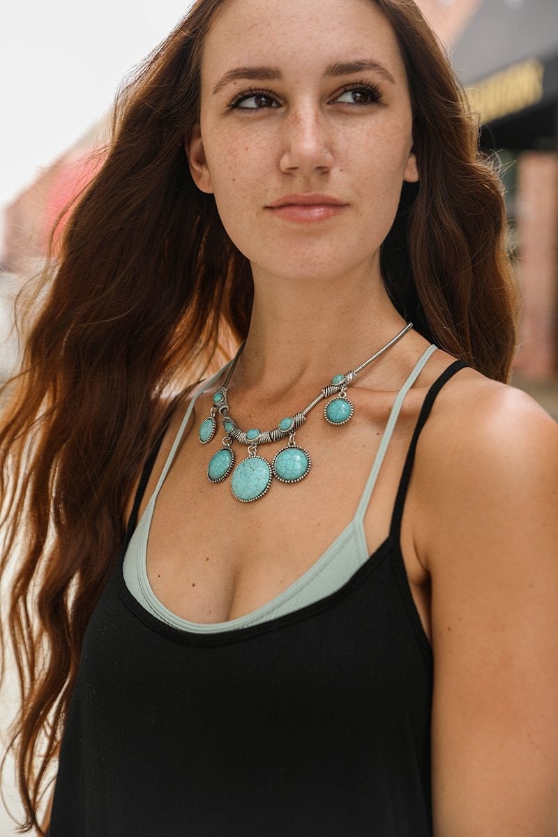 Turquoise Charm Link Necklace featuring five rounded turquoise stones linked on a silver chain, showcasing elegance and style.