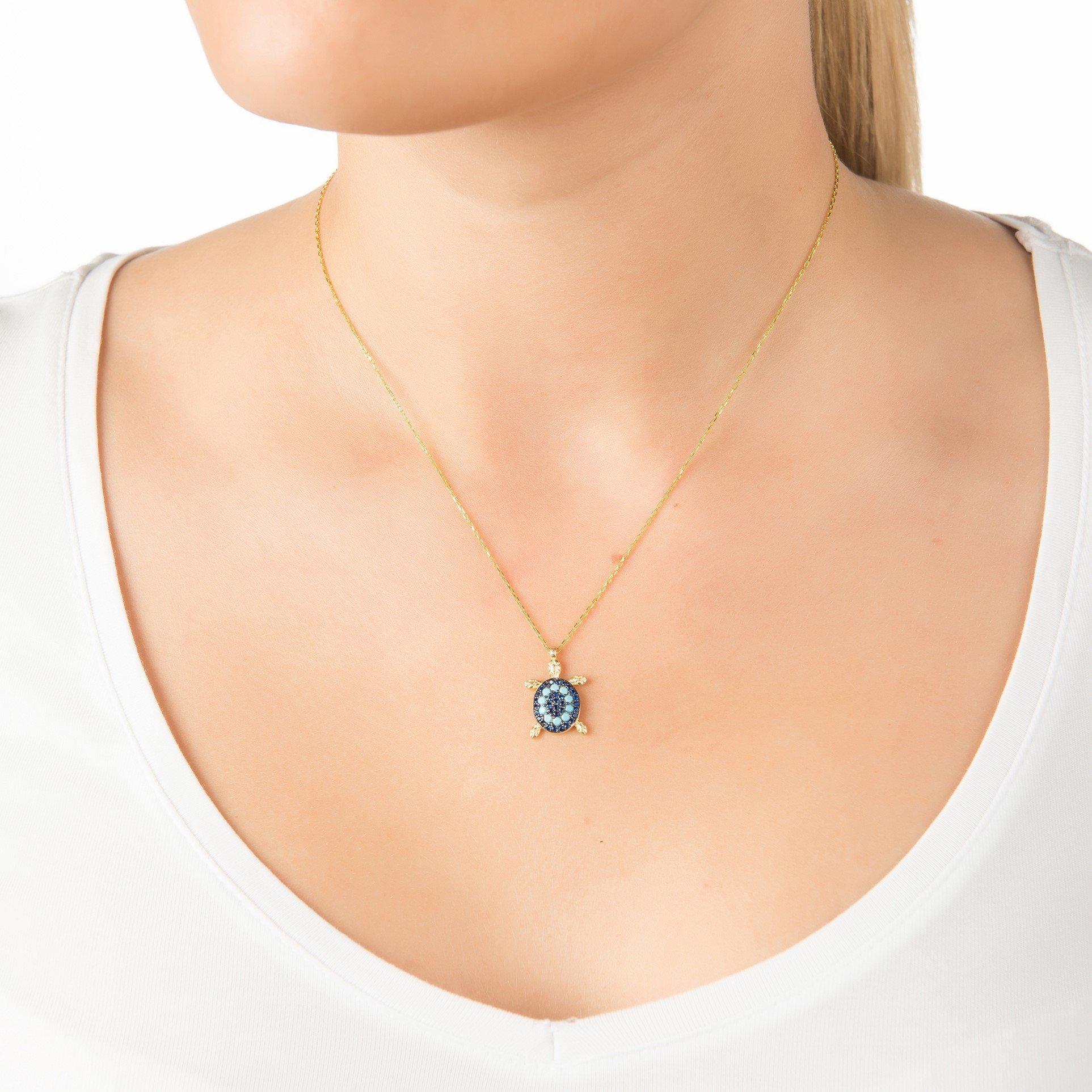 A beautiful Turtle Turquoise Blue Pendant Necklace featuring a gold-plated turtle pendant adorned with sparkling turquoise cubic zirconia on a delicate chain.