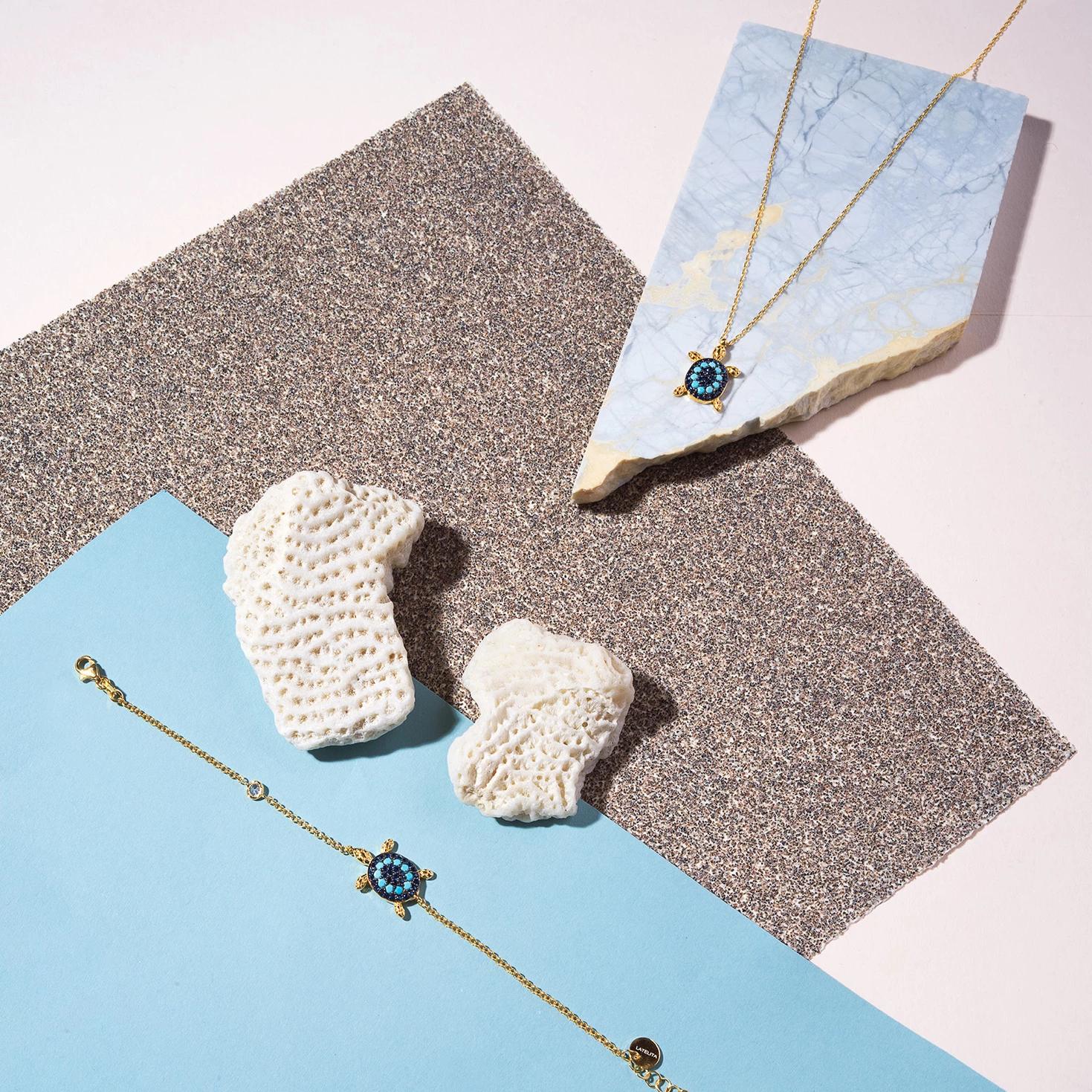 A beautiful Turtle Turquoise Blue Pendant Necklace featuring a gold-plated turtle pendant adorned with sparkling turquoise cubic zirconia on a delicate chain.