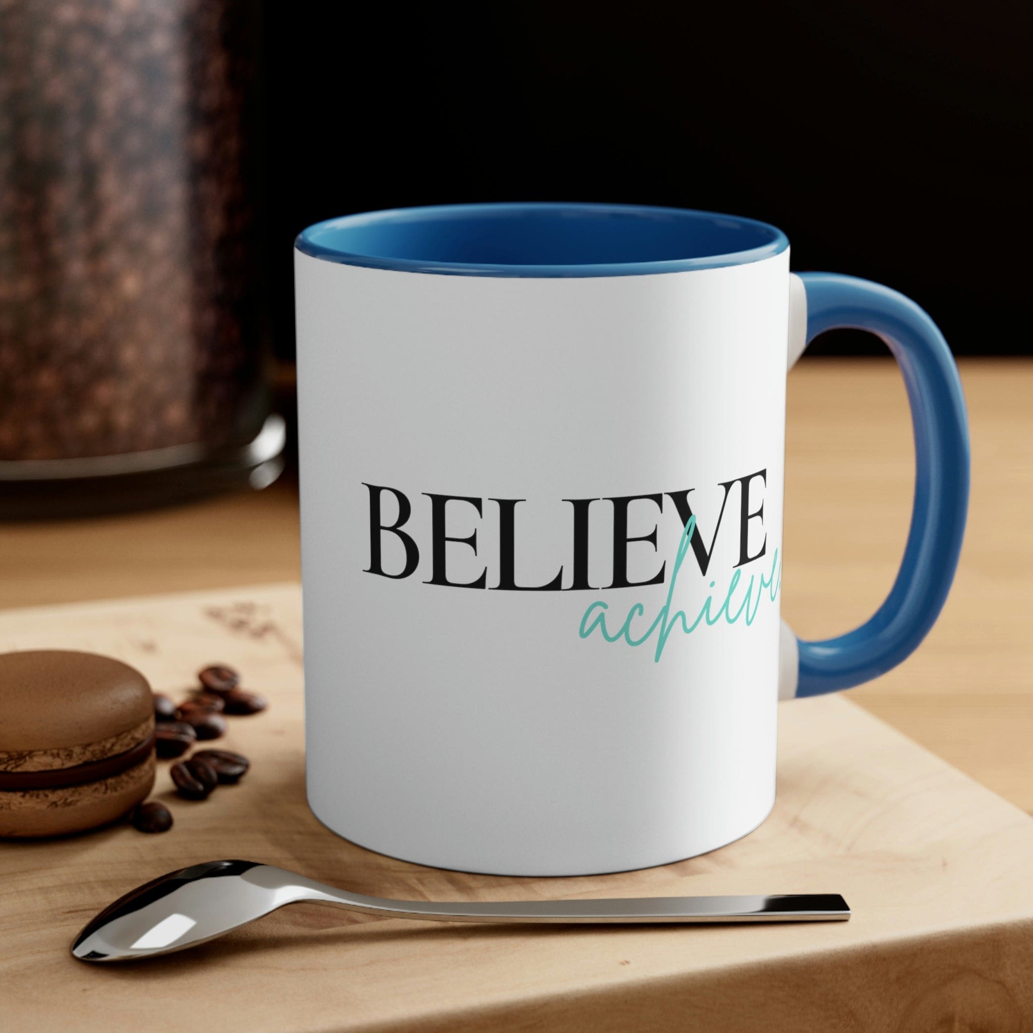 Two-tone ceramic mug with a C-handle, featuring a colorful interior and the inspirational phrase 'Believe and Achieve'.