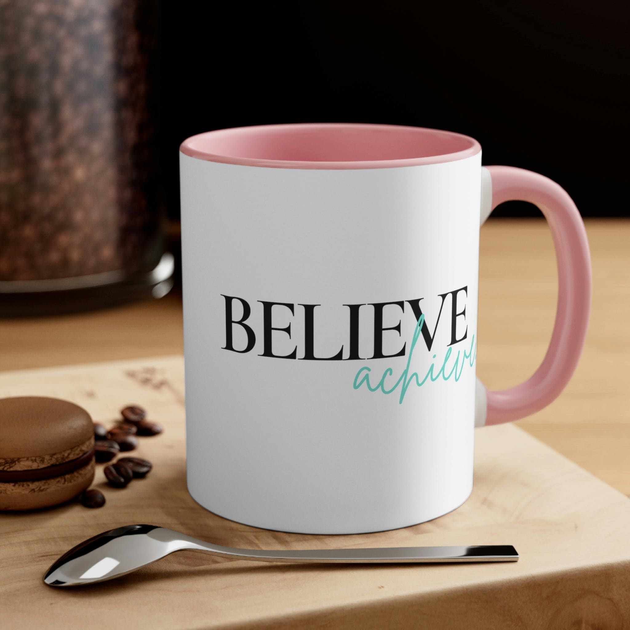 Two-tone ceramic mug with a C-handle, featuring a colorful interior and the inspirational phrase 'Believe and Achieve'.