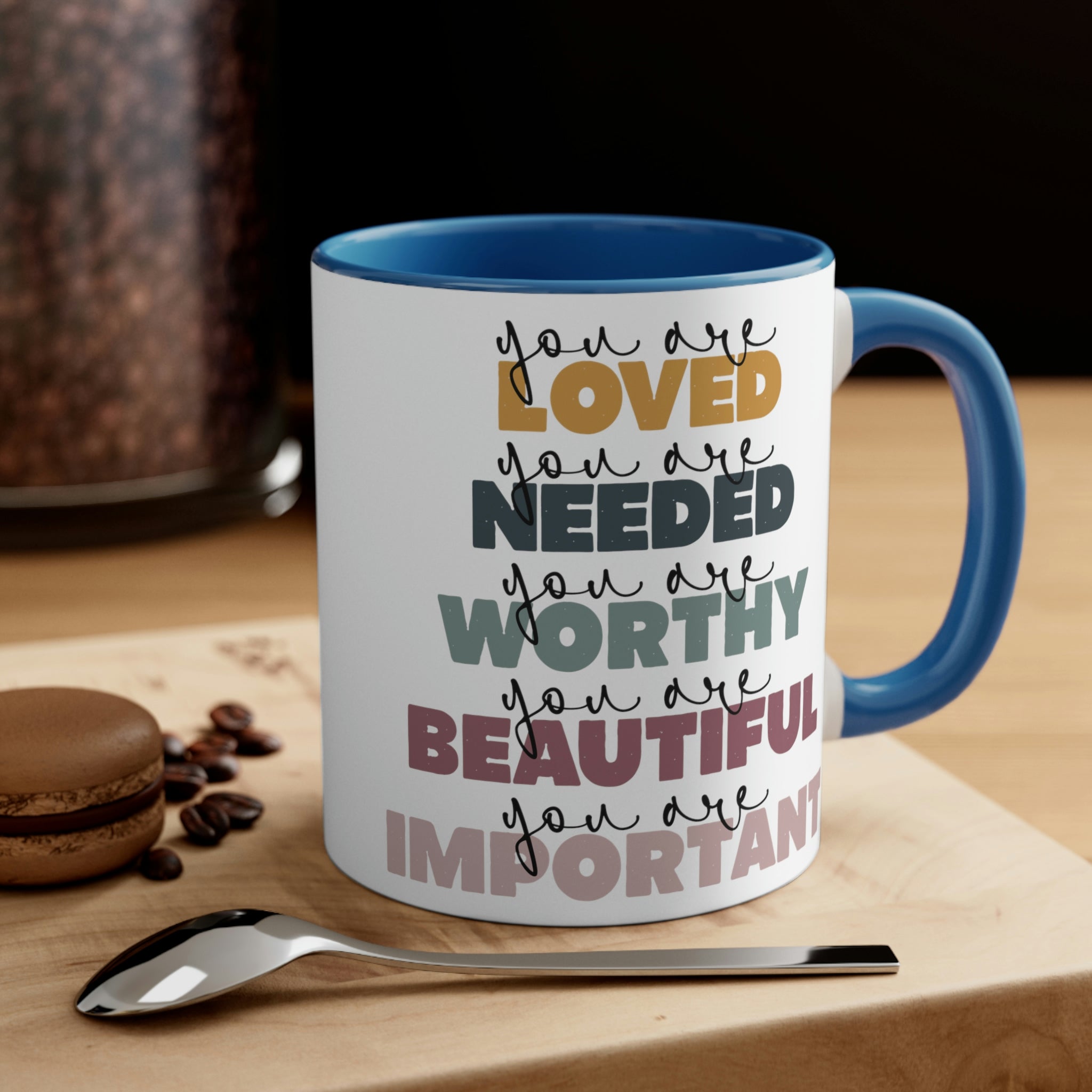 Two-tone ceramic mug with a white exterior and colored interior, featuring a C-handle and the phrase 'you are Loved'.