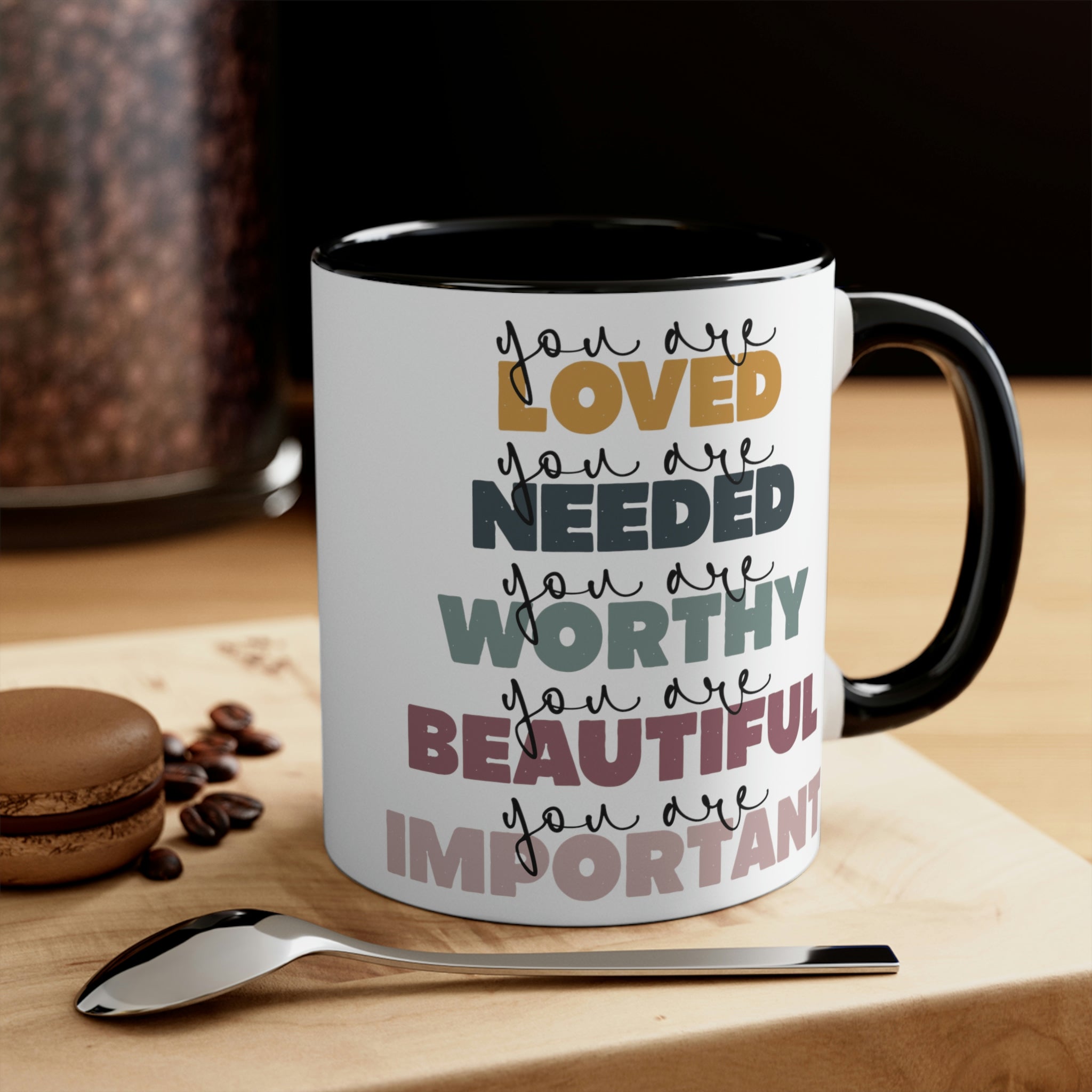 Two-tone ceramic mug with a white exterior and colored interior, featuring a C-handle and the phrase 'you are Loved'.