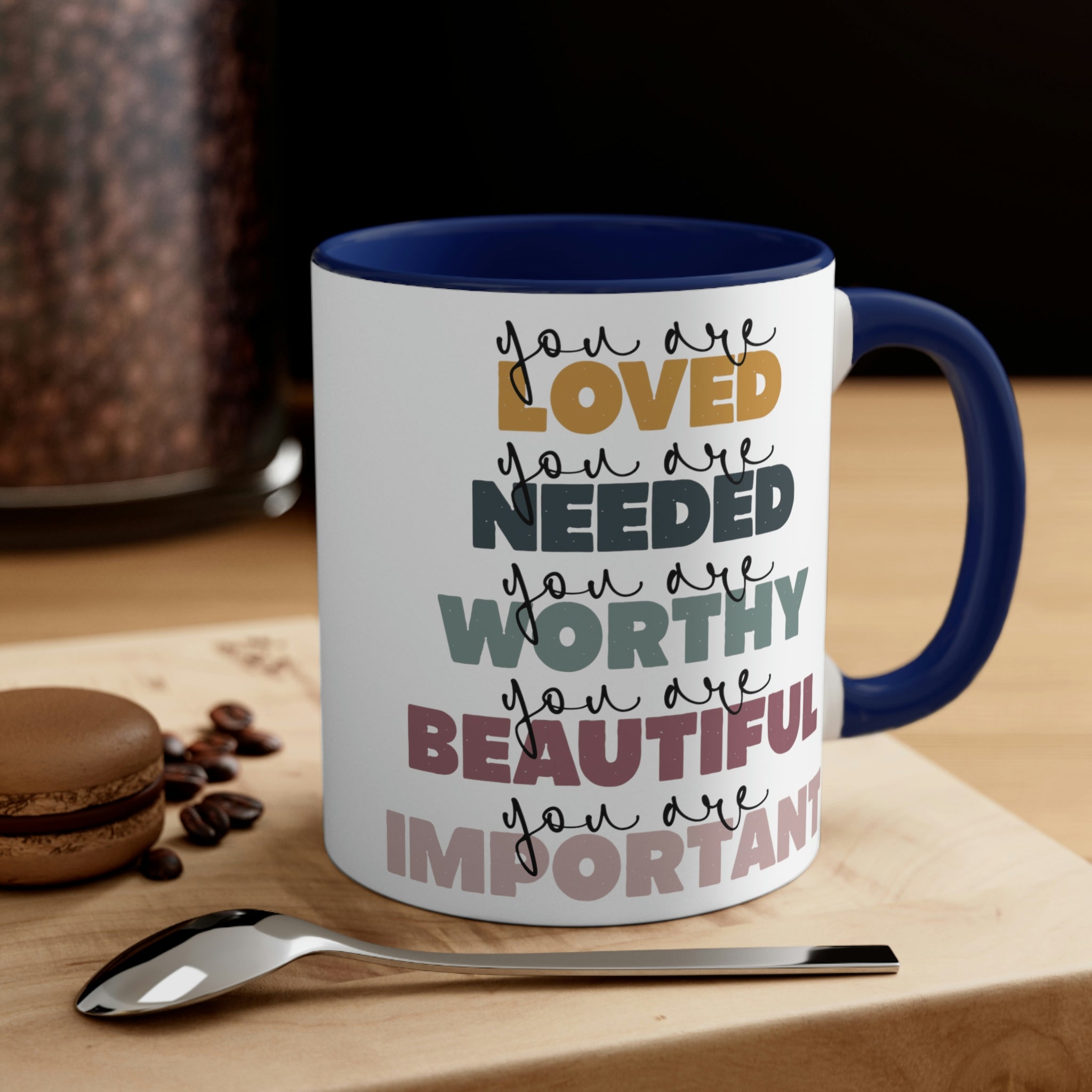 Two-tone ceramic mug with a white exterior and colored interior, featuring a C-handle and the phrase 'you are Loved'.