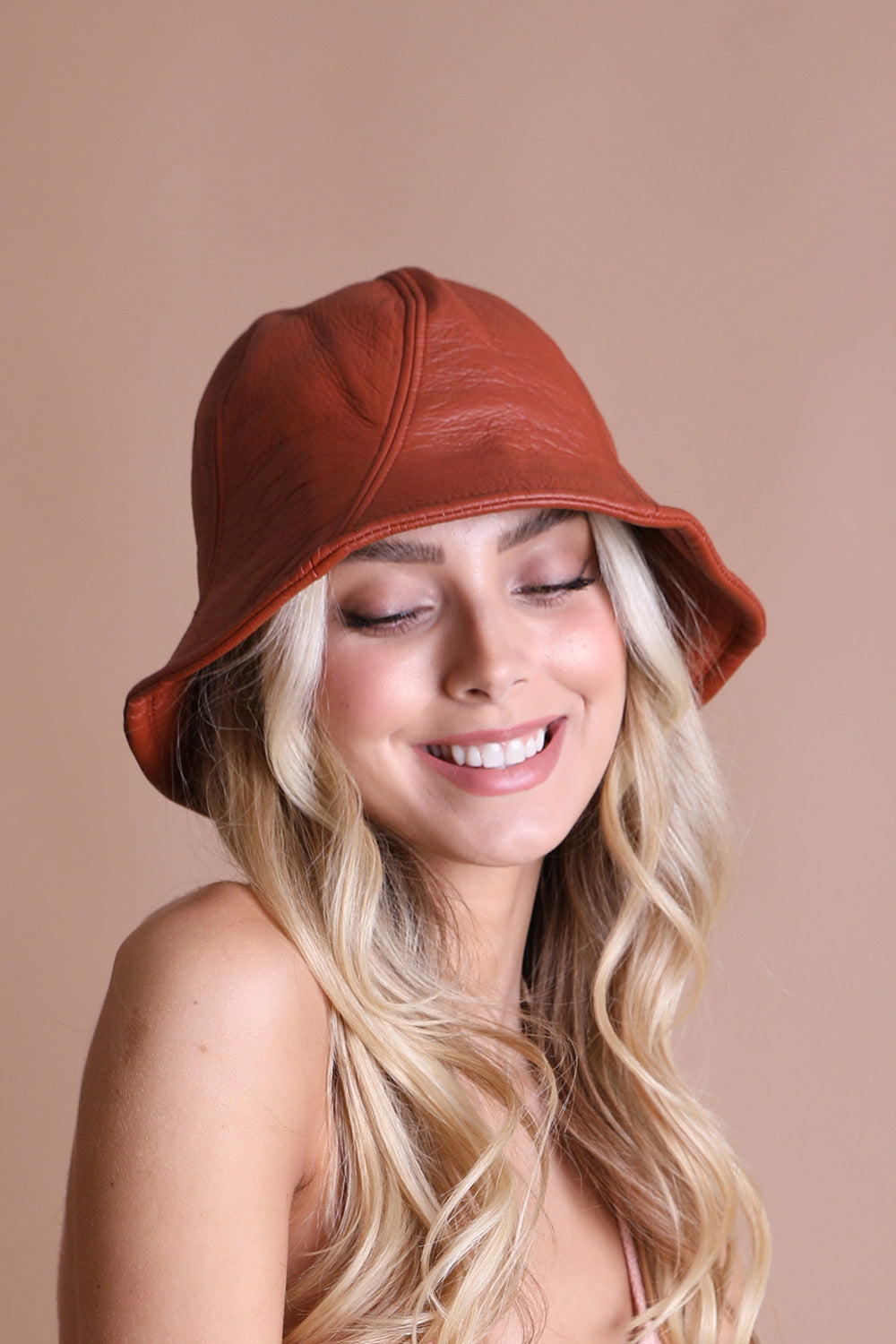 A stylish vegan leather bucket hat in black, featuring an adjustable strap for a perfect fit, ideal for casual and formal occasions.