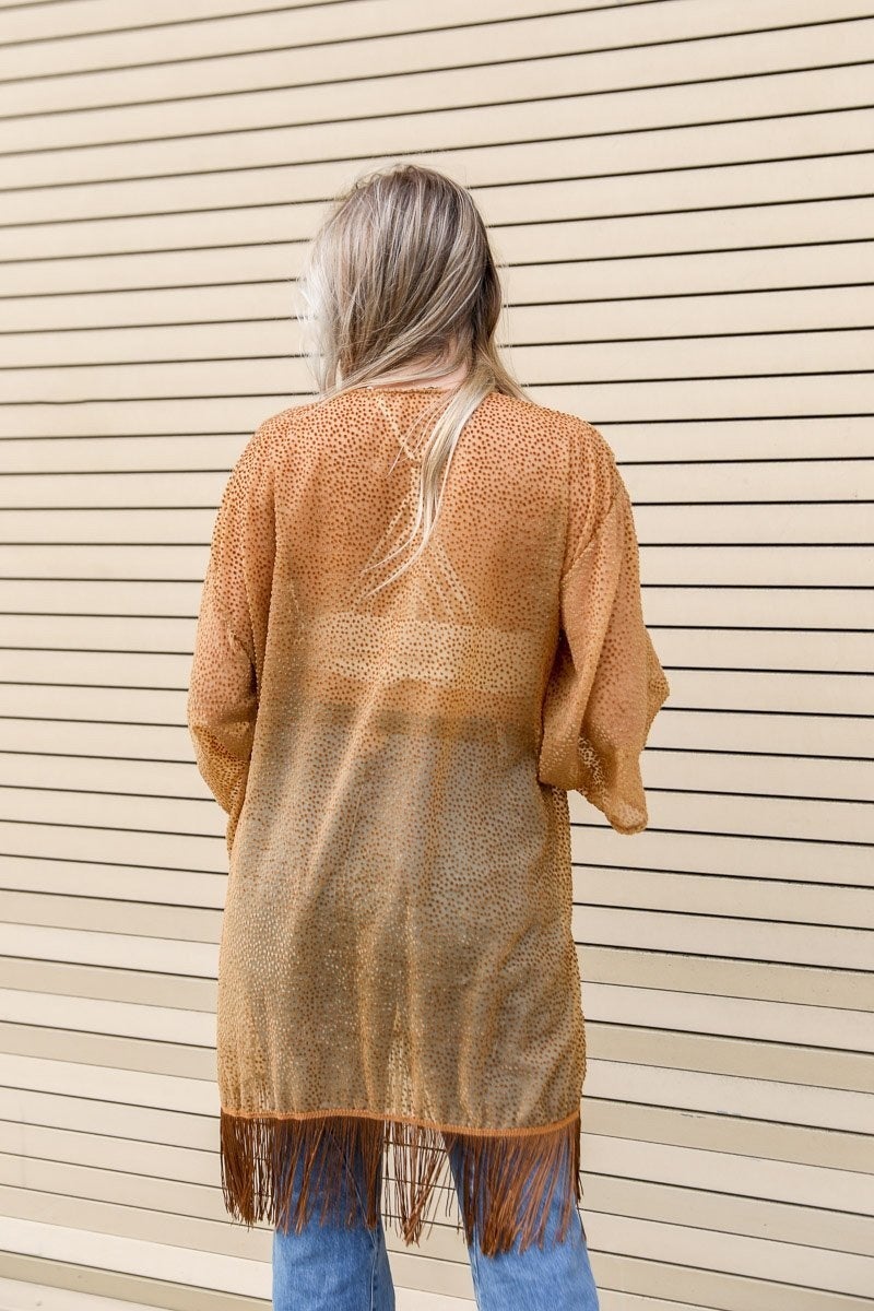 A stylish Velvet Dot Tassel Kimono featuring a textured design and tassel details, perfect for layering over various outfits.