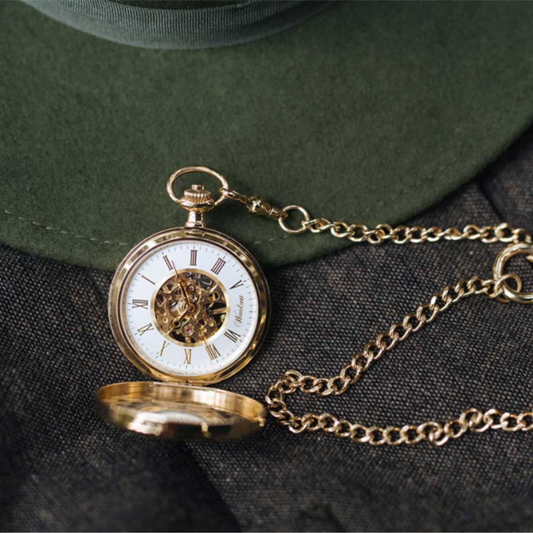 Waidzeit Franz Rudolf Skeleton pocket watch in gold with Roman numerals and root wood finish, showcasing intricate movement through glass windows.