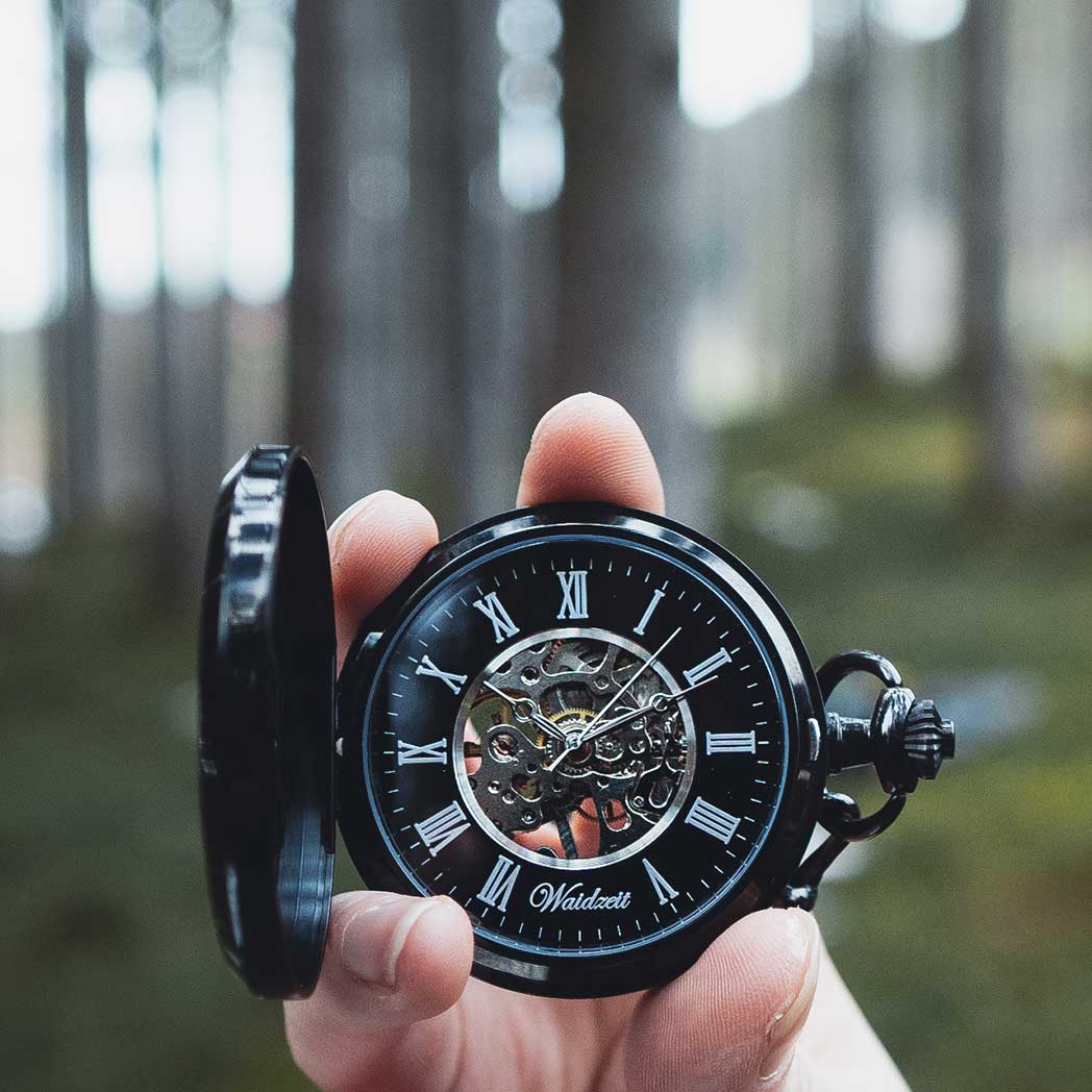 Waidzeit Franz Theodor Skeleton pocket watch featuring a black-plated stainless steel case, white Roman numerals, and a bog oak spring cover.