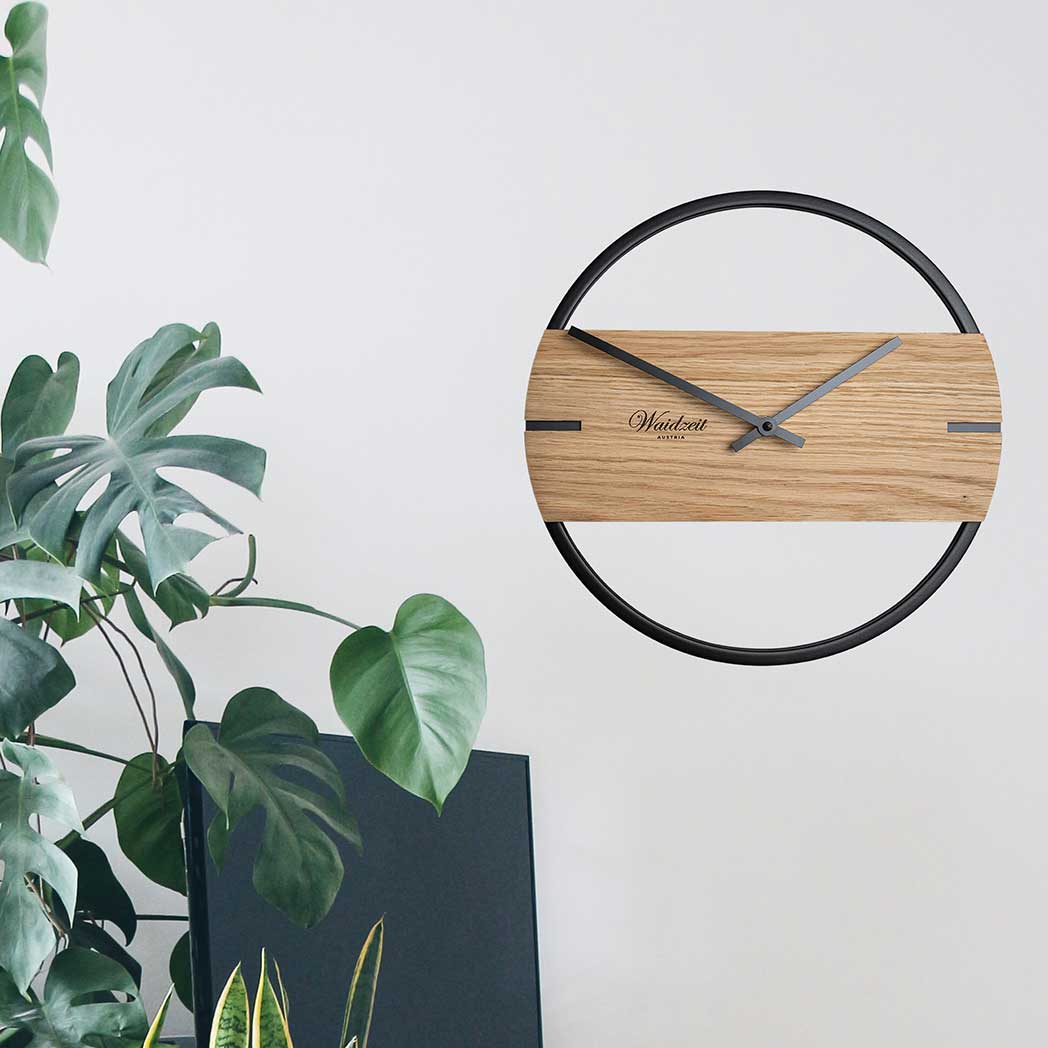 Waidzeit Novum wall clock featuring oak wood and black metal ring, showcasing minimalist Scandinavian design.