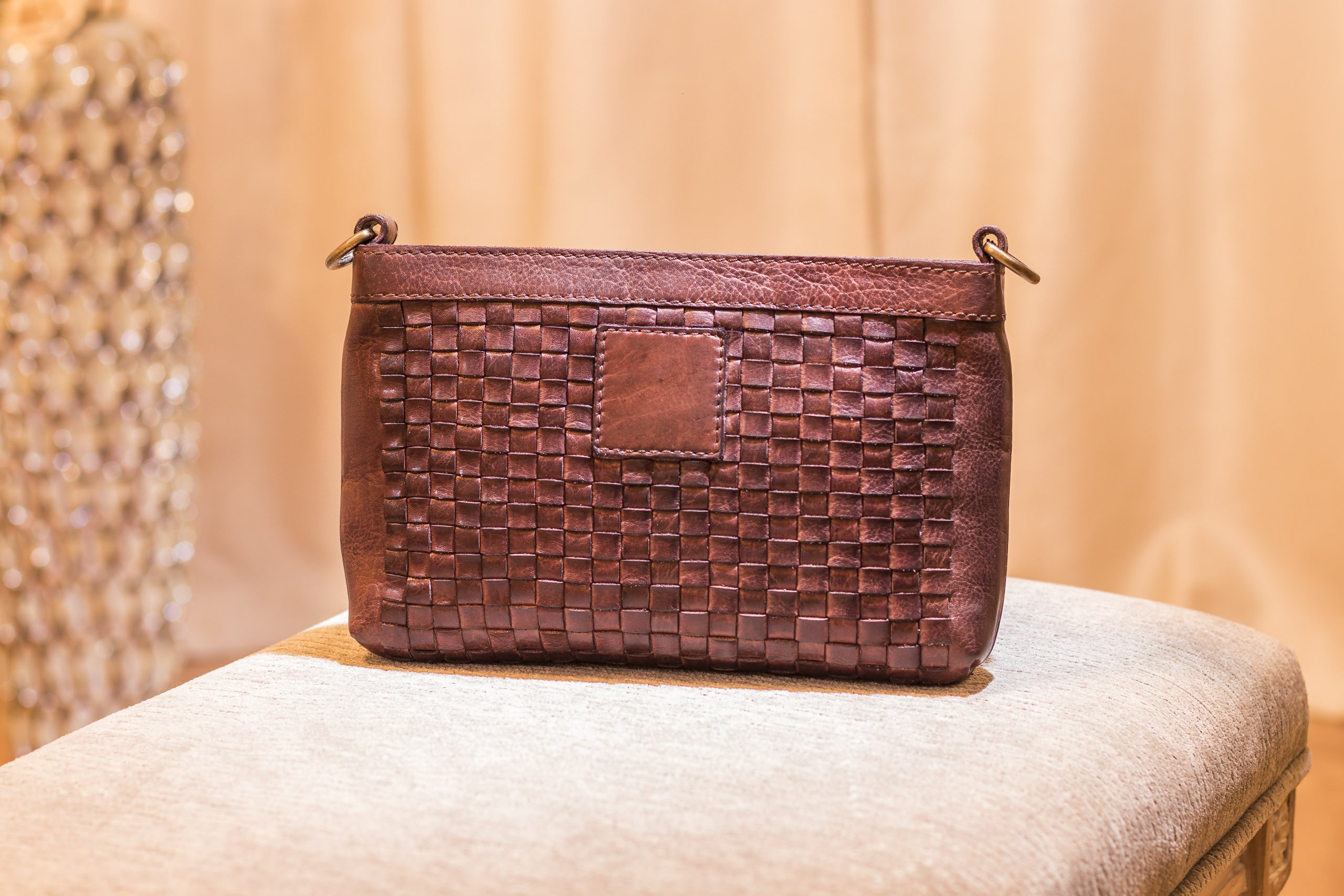 Stylish Weaved Crossbody bag made of genuine washed leather with adjustable strap and zipper pockets.