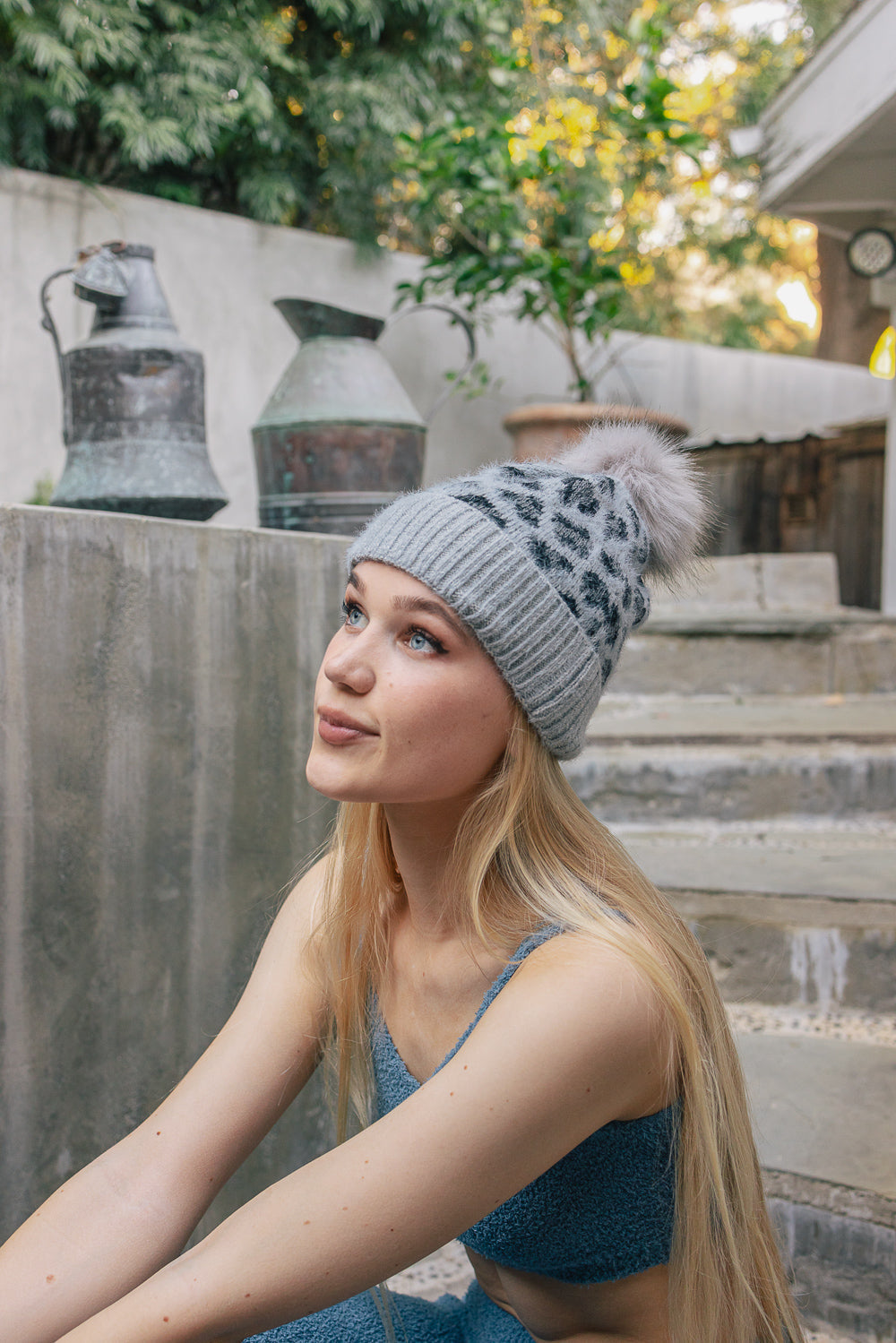 A cozy Wild Leopard Knit Beanie featuring a stylish leopard print design and a playful pom-pom on top, perfect for winter wear.