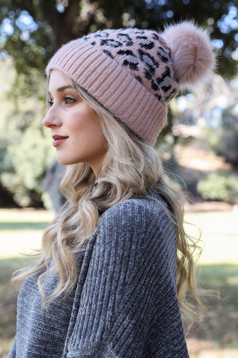 A cozy Wild Leopard Knit Beanie featuring a stylish leopard print design and a playful pom-pom on top, perfect for winter wear.