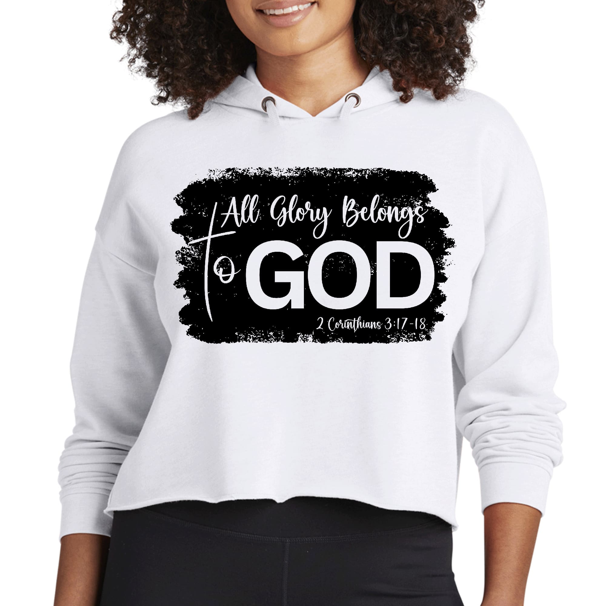 Women's cropped hoodie in black featuring 'All Glory Belongs to God' print, showcasing a stylish design with a double fabric hood and raw edge hem.