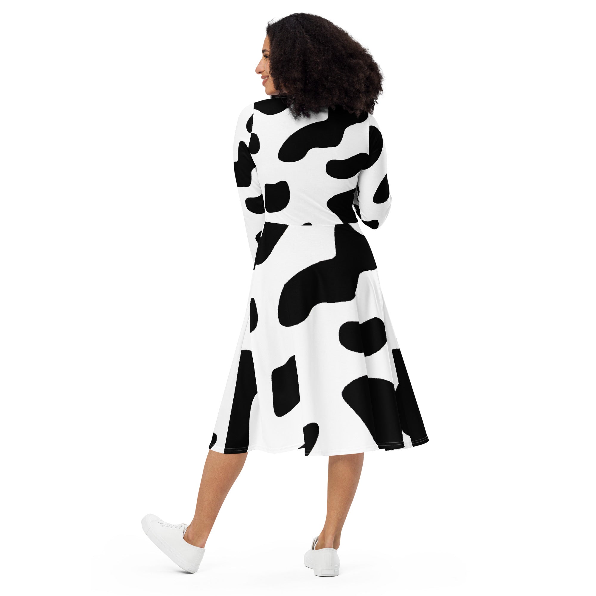 Womens Long Sleeve Midi Dress featuring a stylish black and white cow print, showcasing a fitted waist and flared bottom with side pockets.