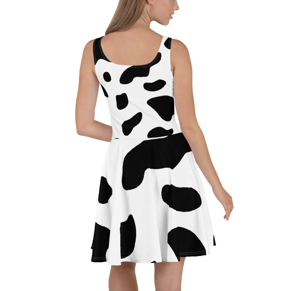 A stylish women's skater dress featuring a black and white cow print design, showcasing a flattering A-line silhouette and sleeveless style.