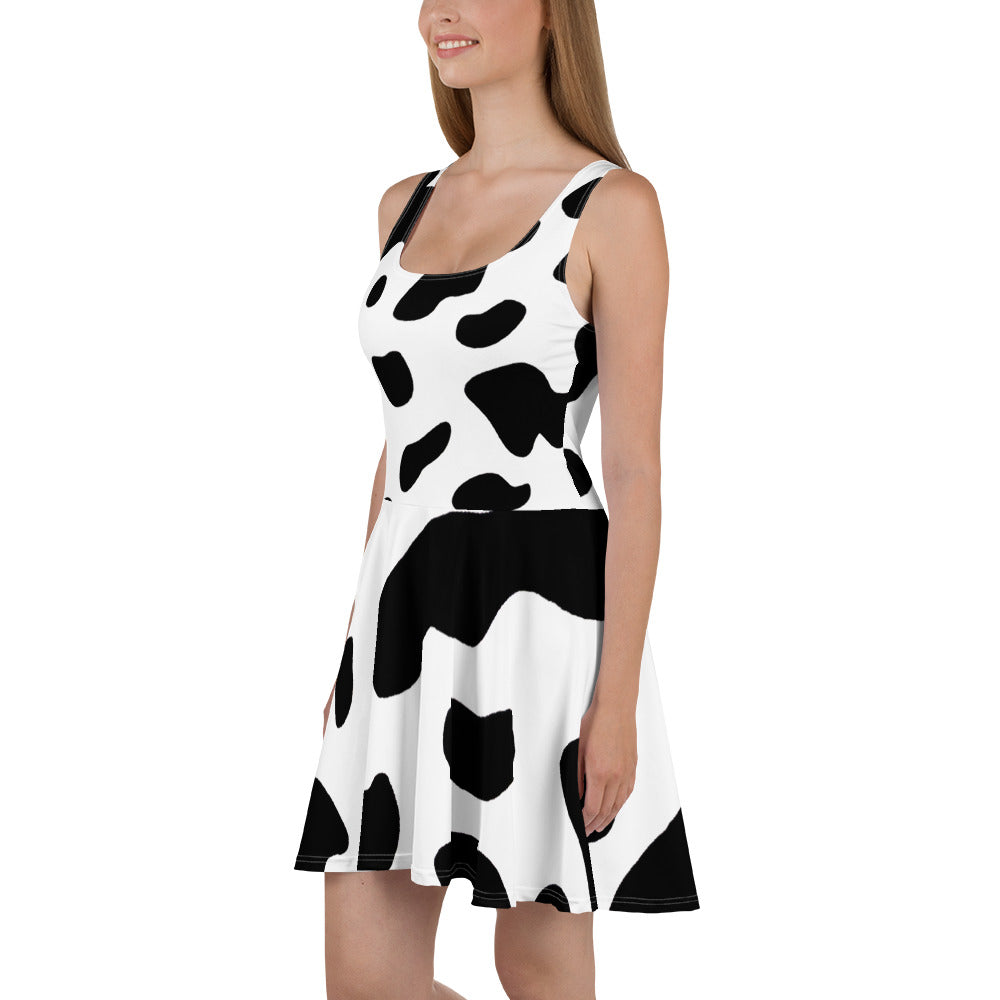 A stylish women's skater dress featuring a black and white cow print design, showcasing a flattering A-line silhouette and sleeveless style.