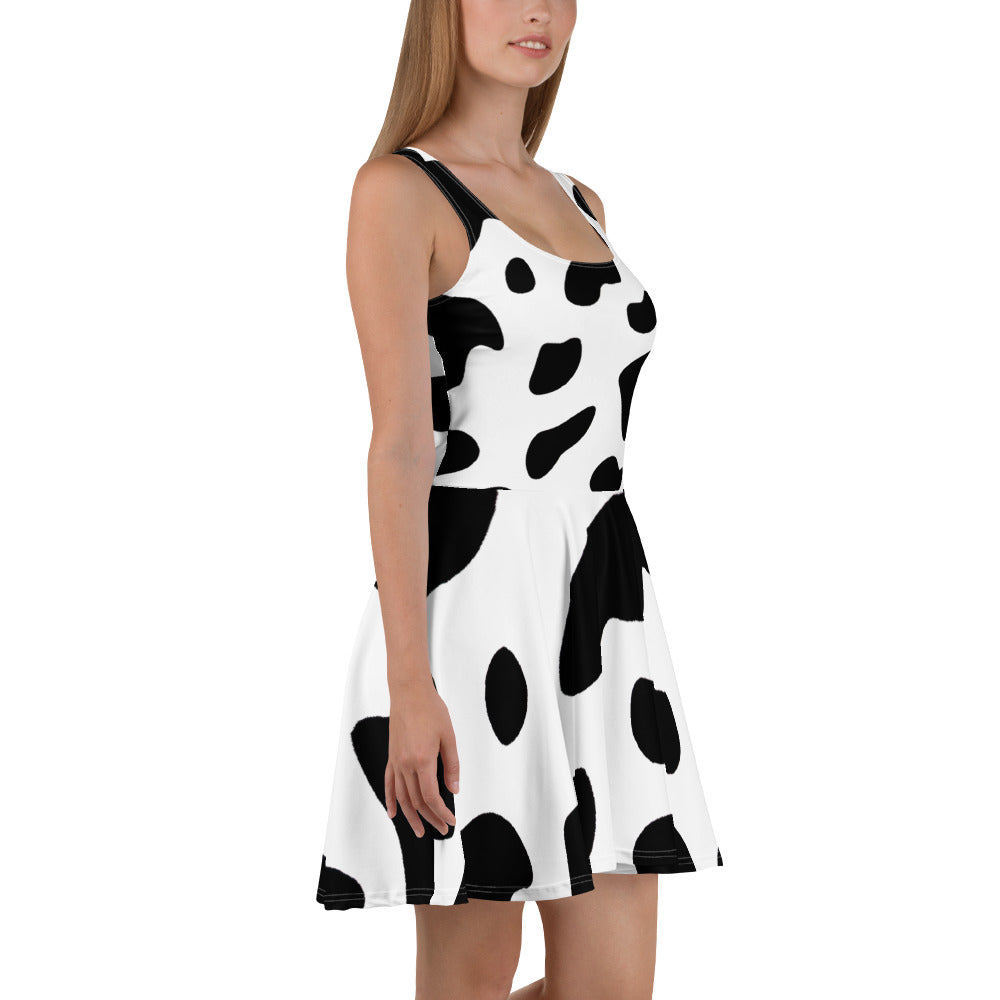 A stylish women's skater dress featuring a black and white cow print design, showcasing a flattering A-line silhouette and sleeveless style.