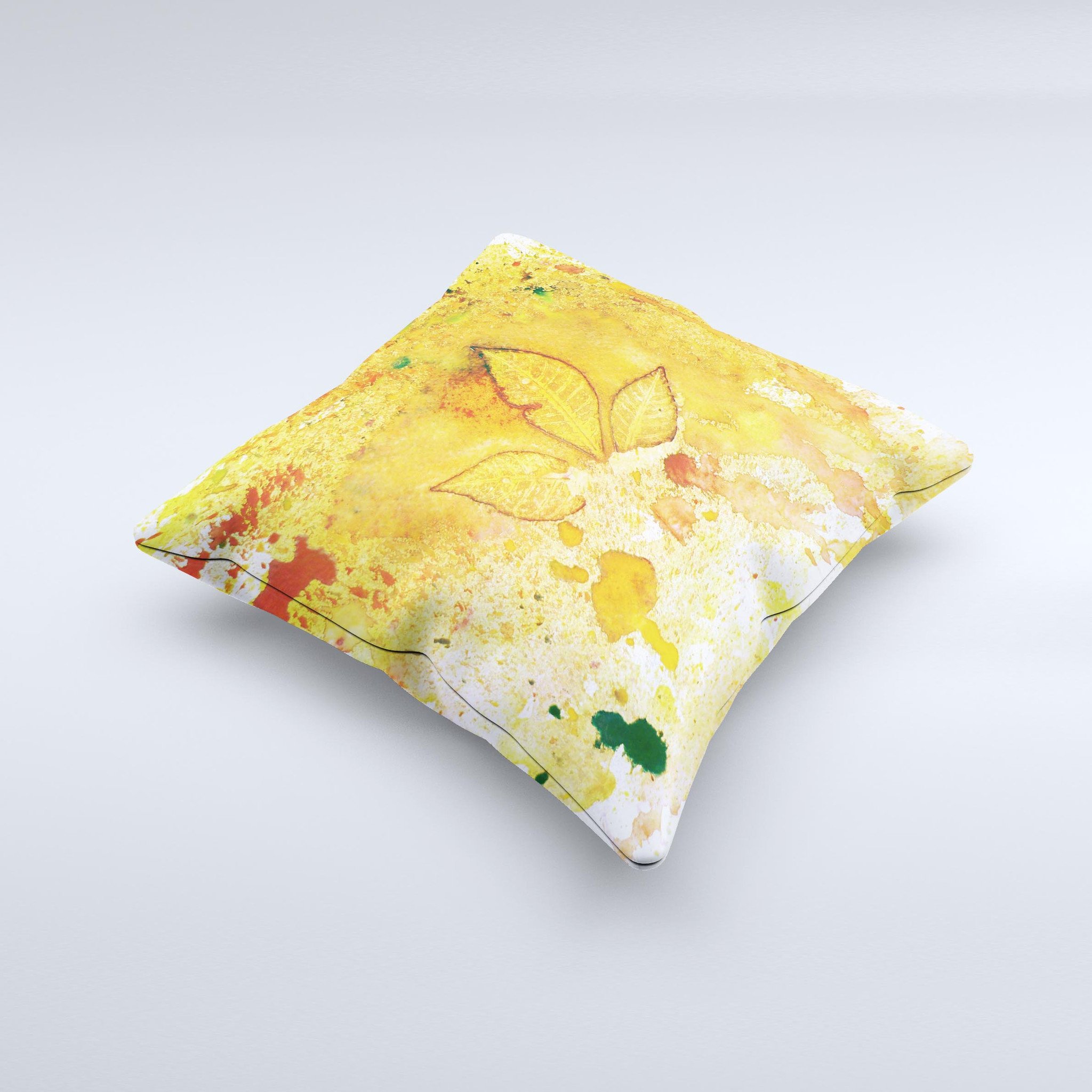 A vibrant yellow leaf-imprinted decorative throw pillow with paint splatter design, handcrafted in Virginia, showcasing unique artistic details.