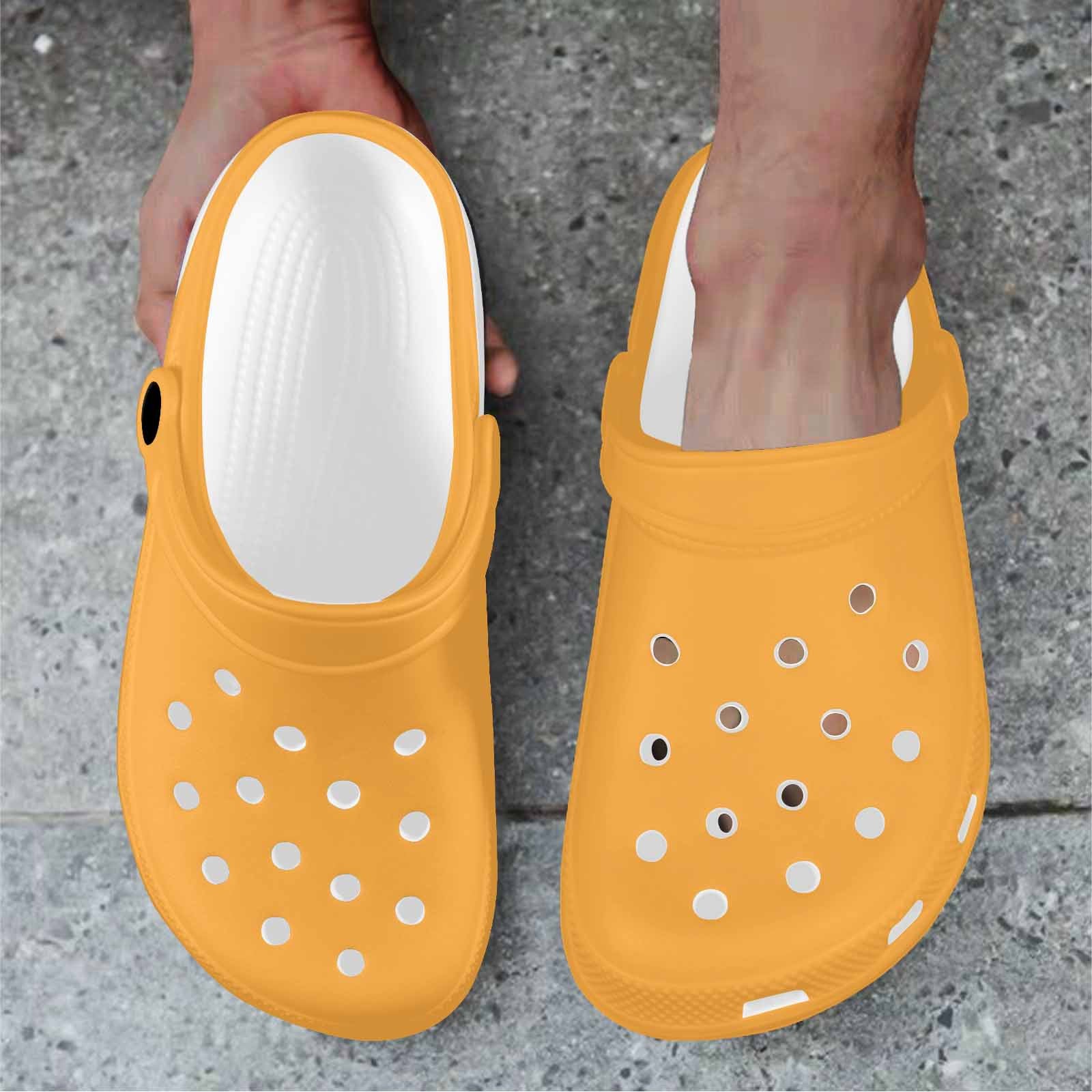 A pair of vibrant yellow-orange adult clogs made from lightweight EVA material, featuring ventilation ports and pivoting heel straps.