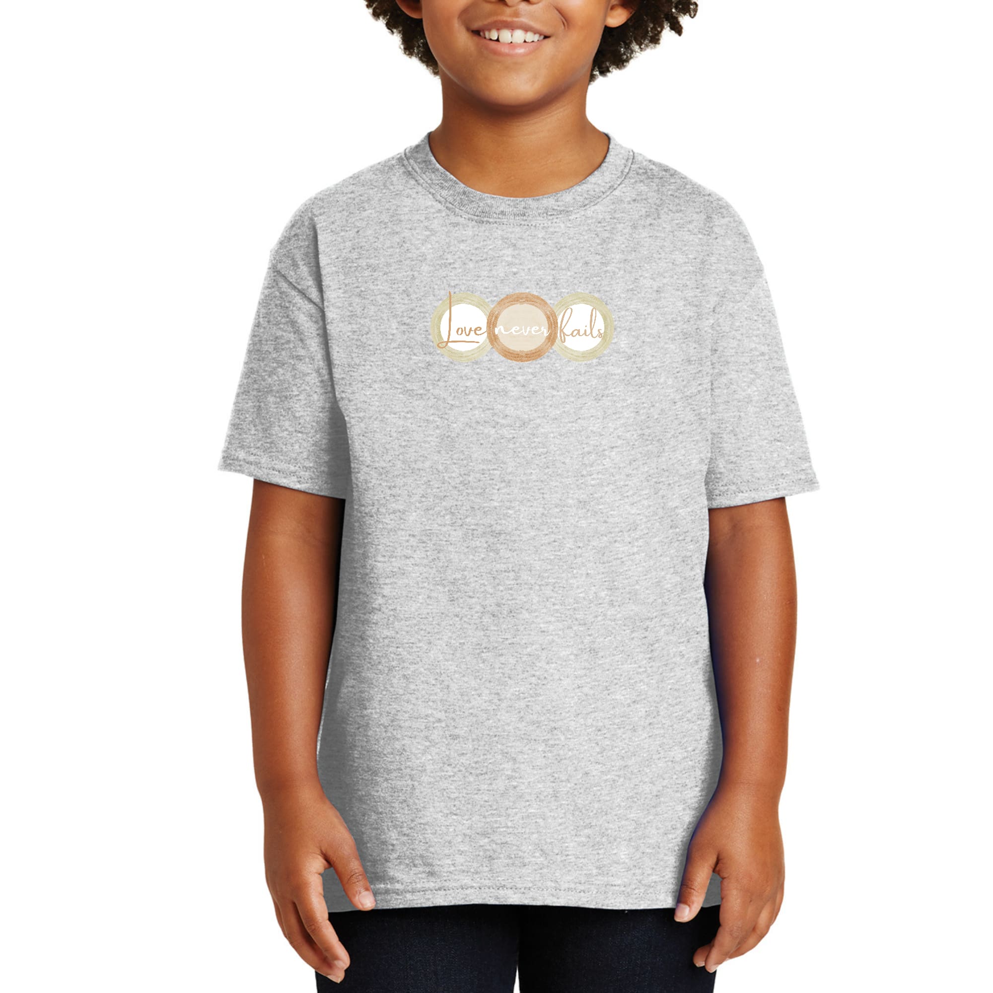 Youth Short Sleeve Graphic T-shirt in pastel brown featuring 'Love Never Fails' design with circular shapes.