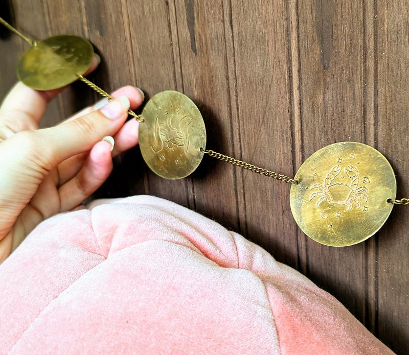 A beautifully crafted brass wall hanging featuring the 12 zodiac signs, showcasing a rustic and antiqued design, perfect for home decor.