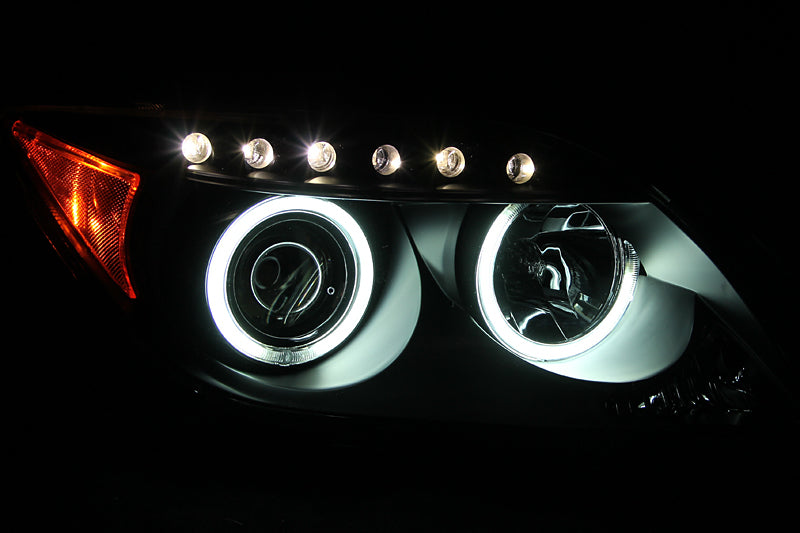 ANZO 2005-2010 Scion tC projector headlights with black housing and halo CCFL rings, showcasing modern automotive lighting design.