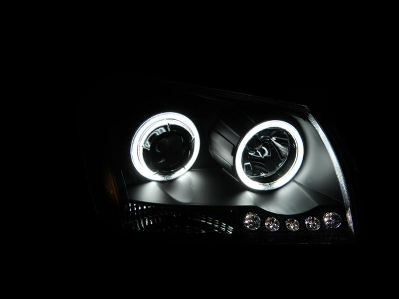 ANZO 2005-2007 Dodge Magnum projector headlights with black housing and halo rings, showcasing clear lens design.