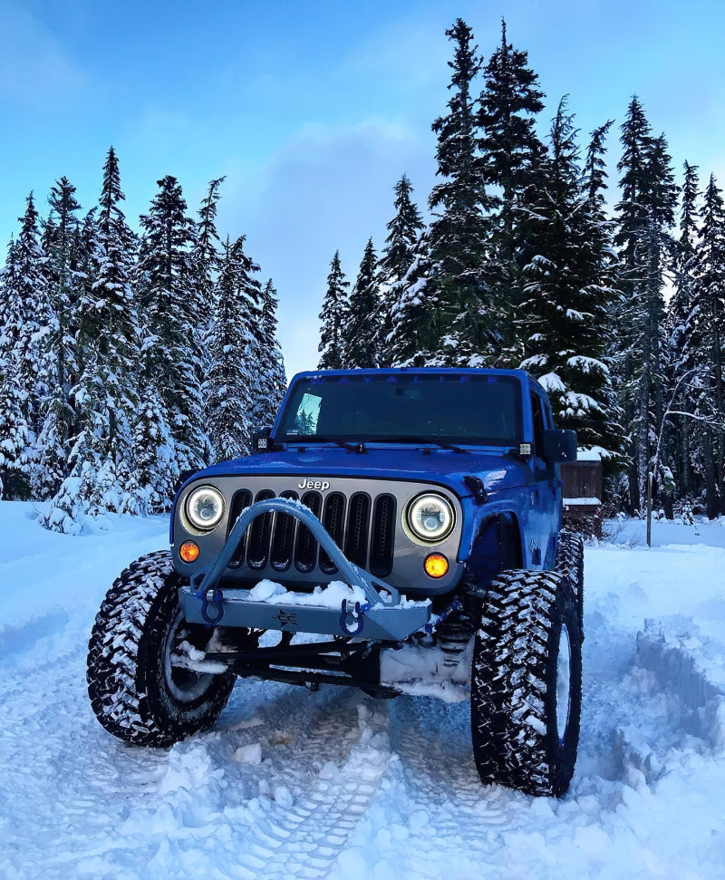 Oracle 7in High Powered LED Headlights with black bezel and white light, showcasing rugged design for Jeep and off-road vehicles.