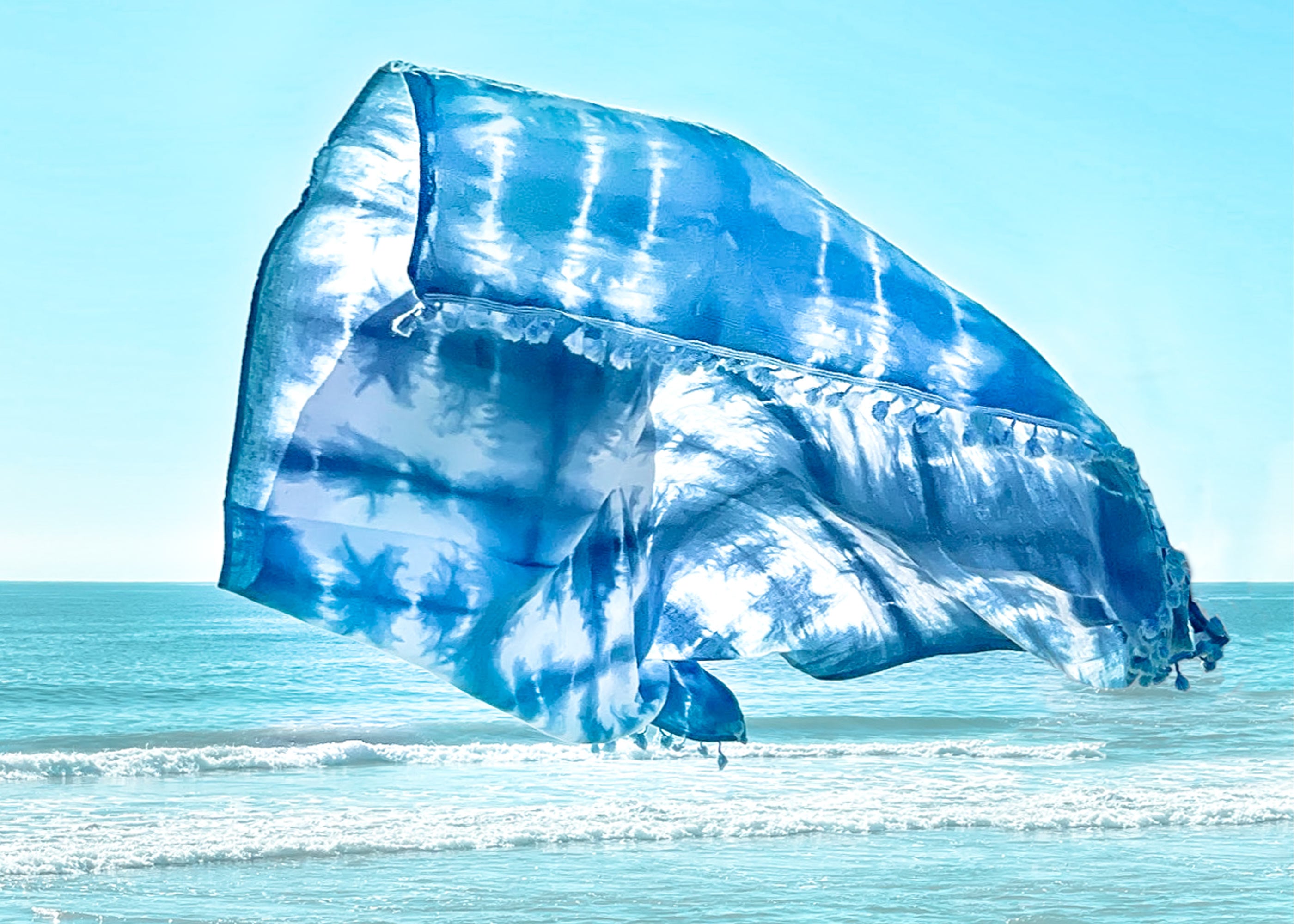 A unique indigo-dyed beach blanket made from soft cotton, showcasing beautiful patterns and vibrant colors, perfect for beach outings or home decor.