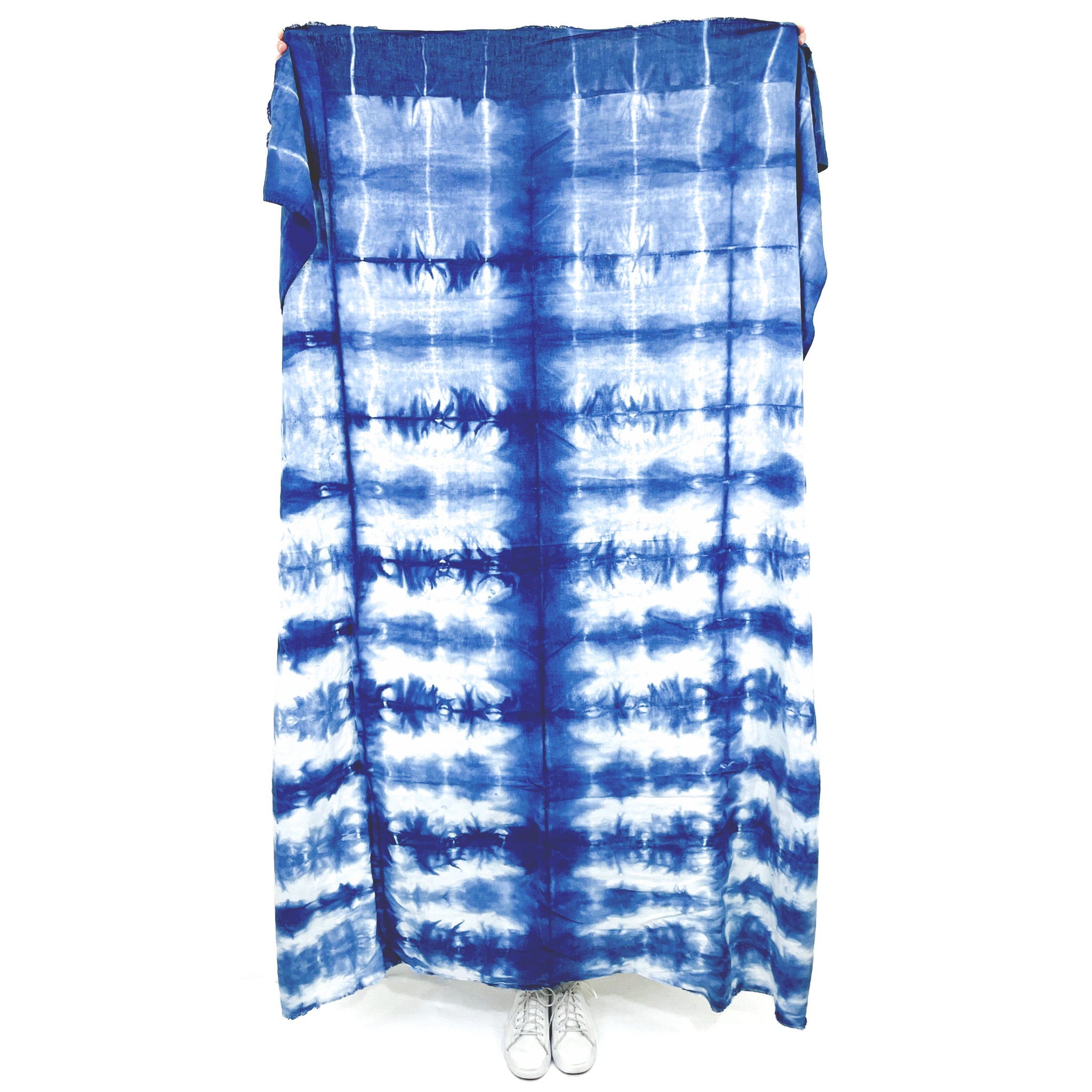 A unique indigo-dyed beach blanket made from soft cotton, showcasing beautiful patterns and vibrant colors, perfect for beach outings or home decor.