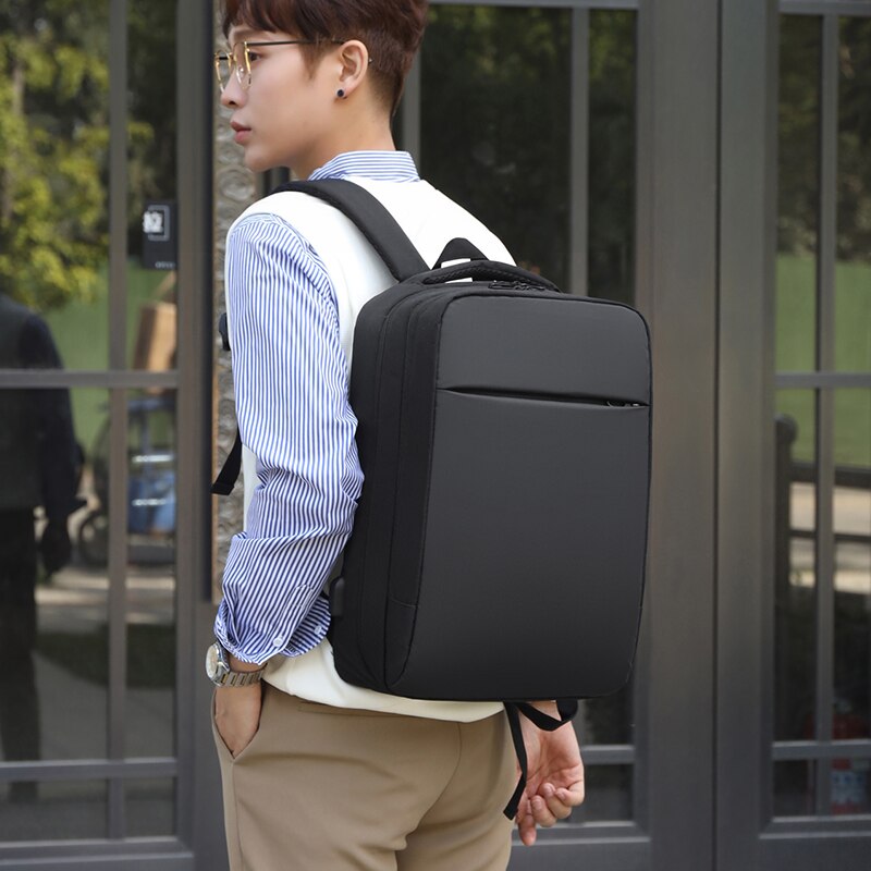 Large-capacity waterproof business backpack for men with USB charging port, featuring a stylish patchwork design and comfortable air cushion belt.