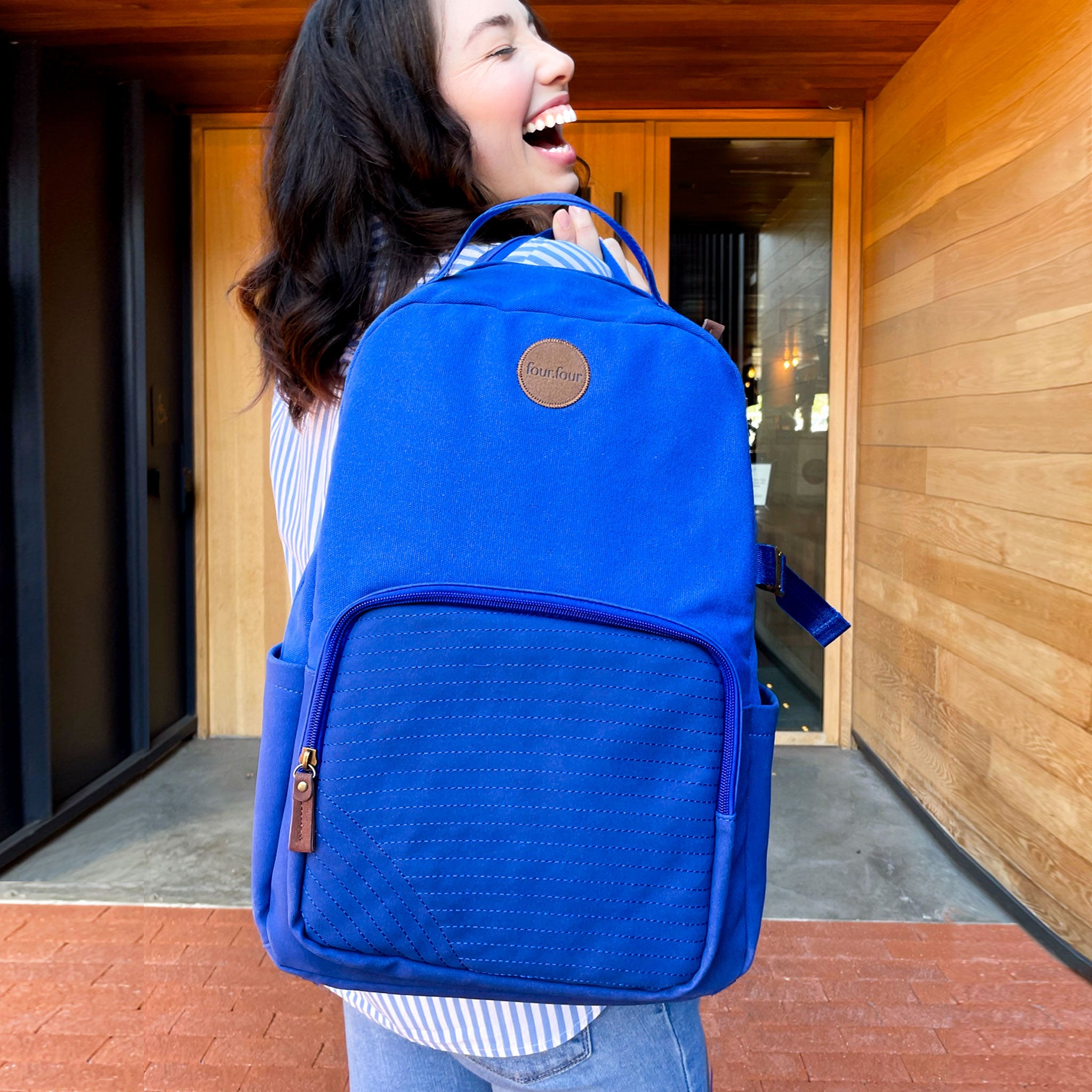 Eternal Optimist Cobalt Blue Backpack featuring a secret back pocket, padded laptop compartment, and eco-friendly materials.